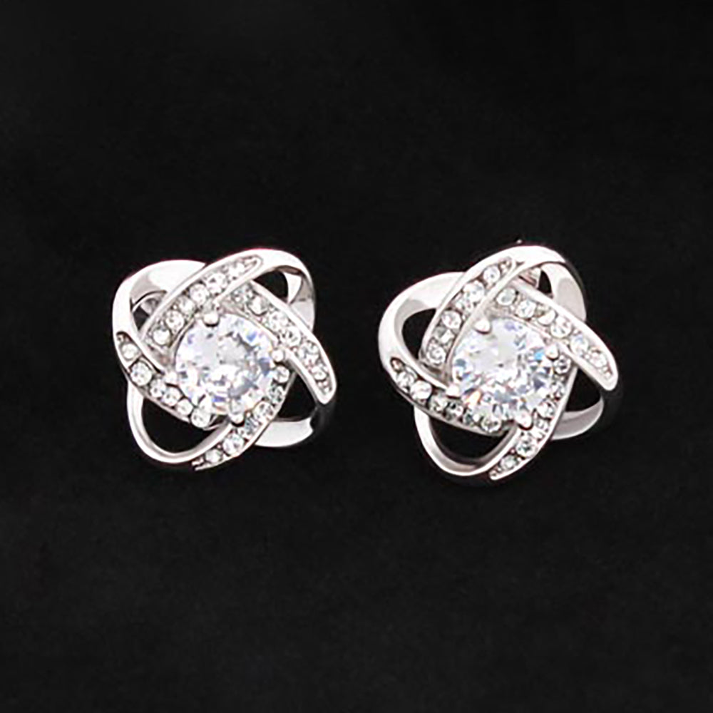 A pair of elegant Love Knot Stud Earrings made of 14K white gold over stainless steel, featuring a sparkling 6mm cubic zirconia center.