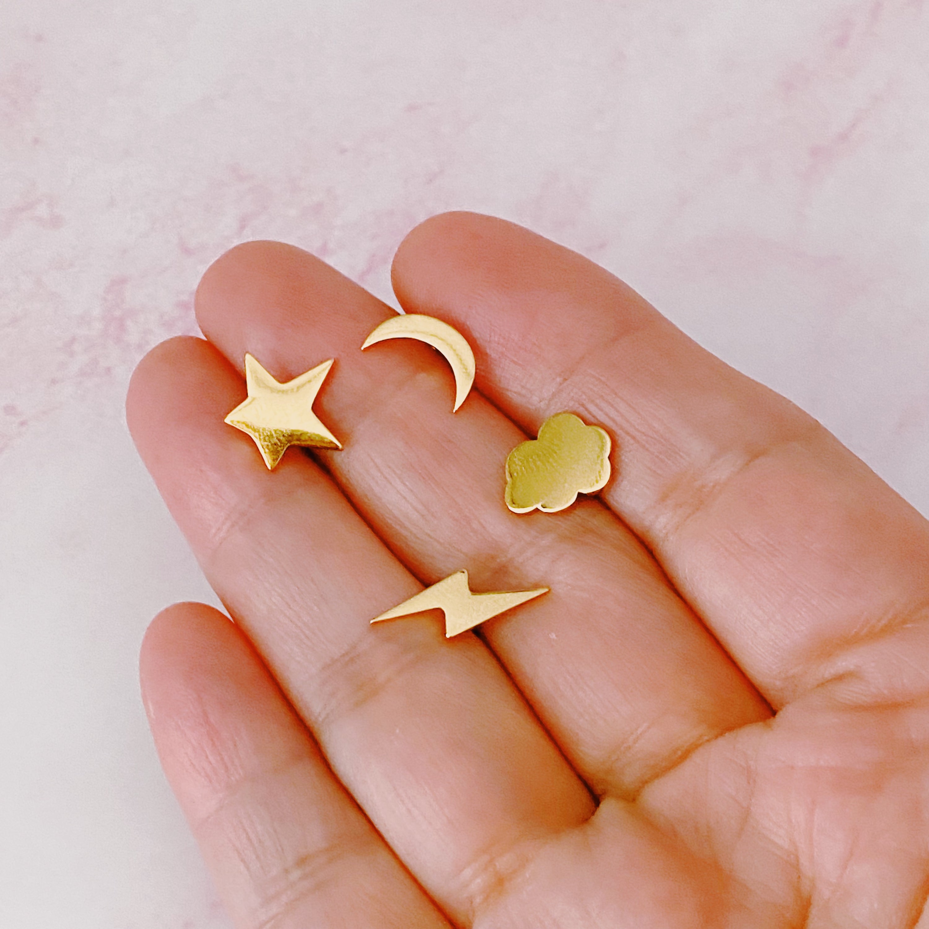 A set of four delicate stud earrings in unique shapes, showcasing 18k gold plating and premium craftsmanship.