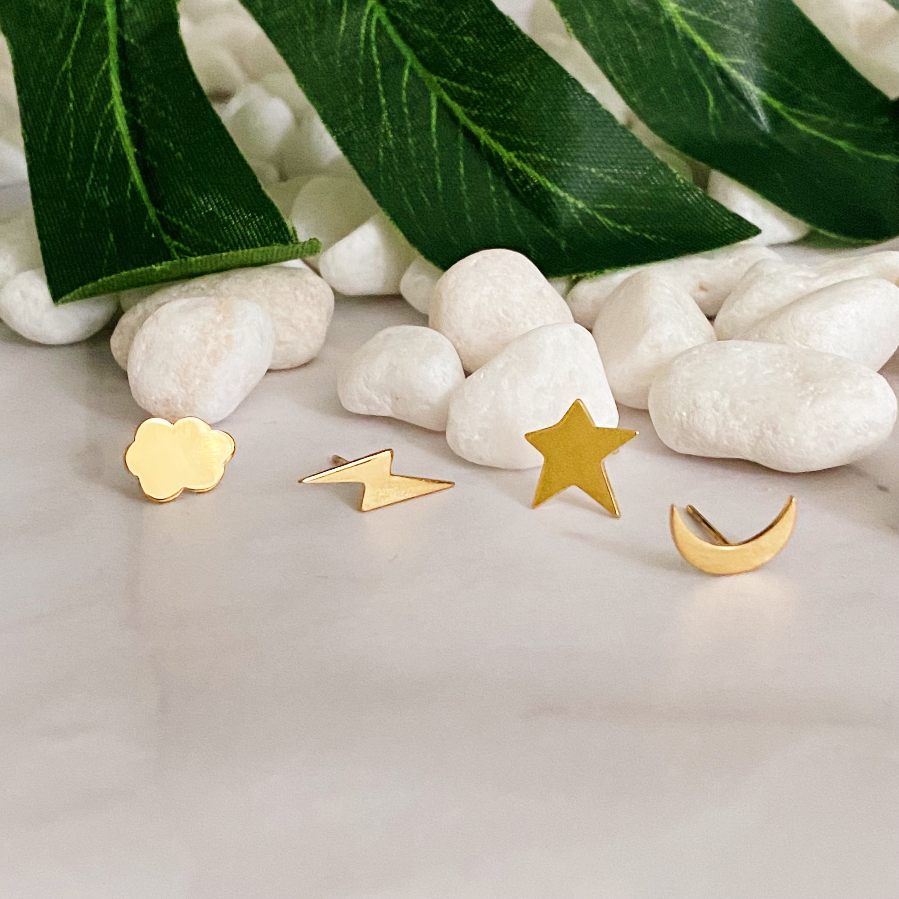 A set of four delicate stud earrings in unique shapes, showcasing 18k gold plating and premium craftsmanship.