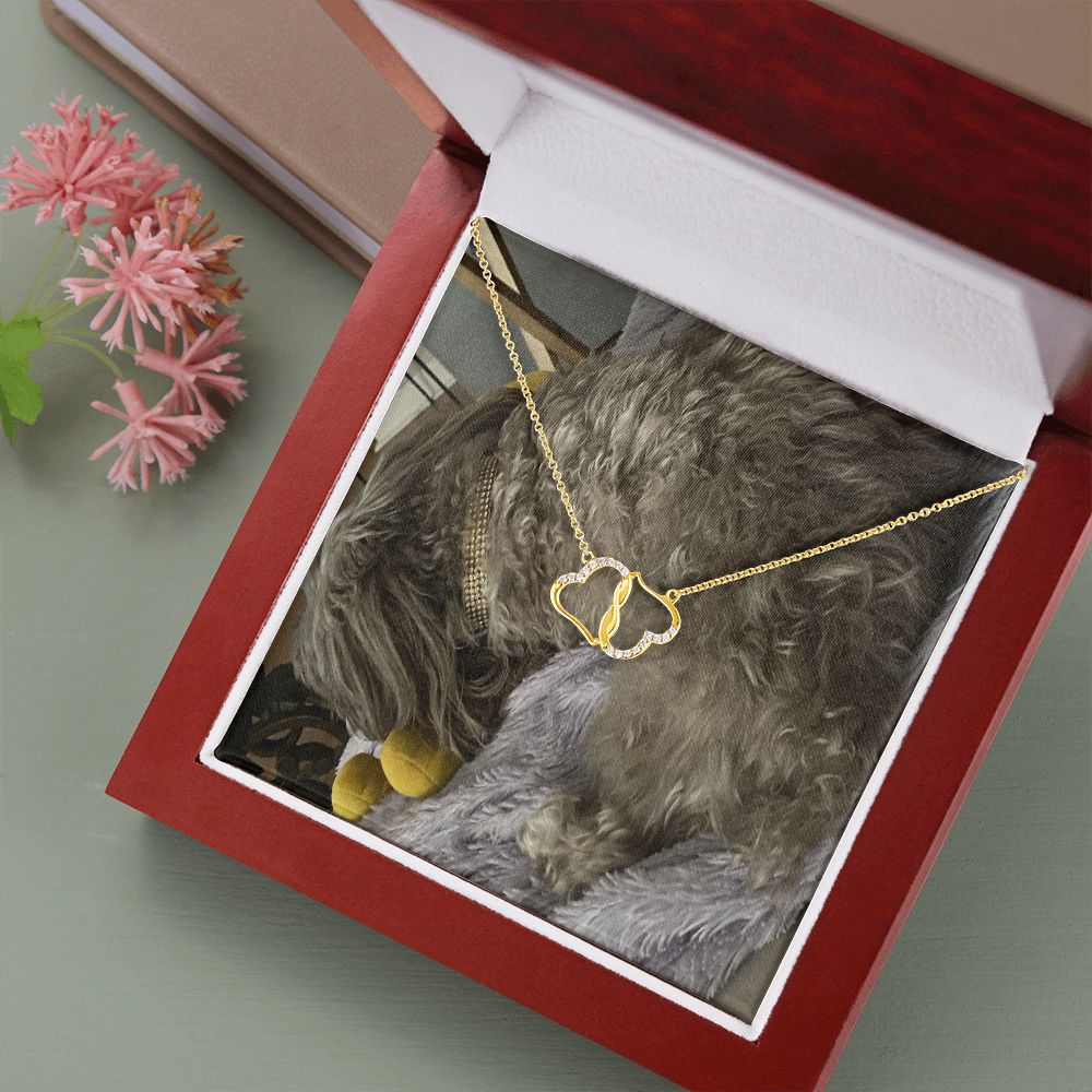 A beautiful 10K solid yellow gold necklace featuring two interconnected hearts adorned with 18 pave set diamonds, presented in a luxurious mahogany gift box.