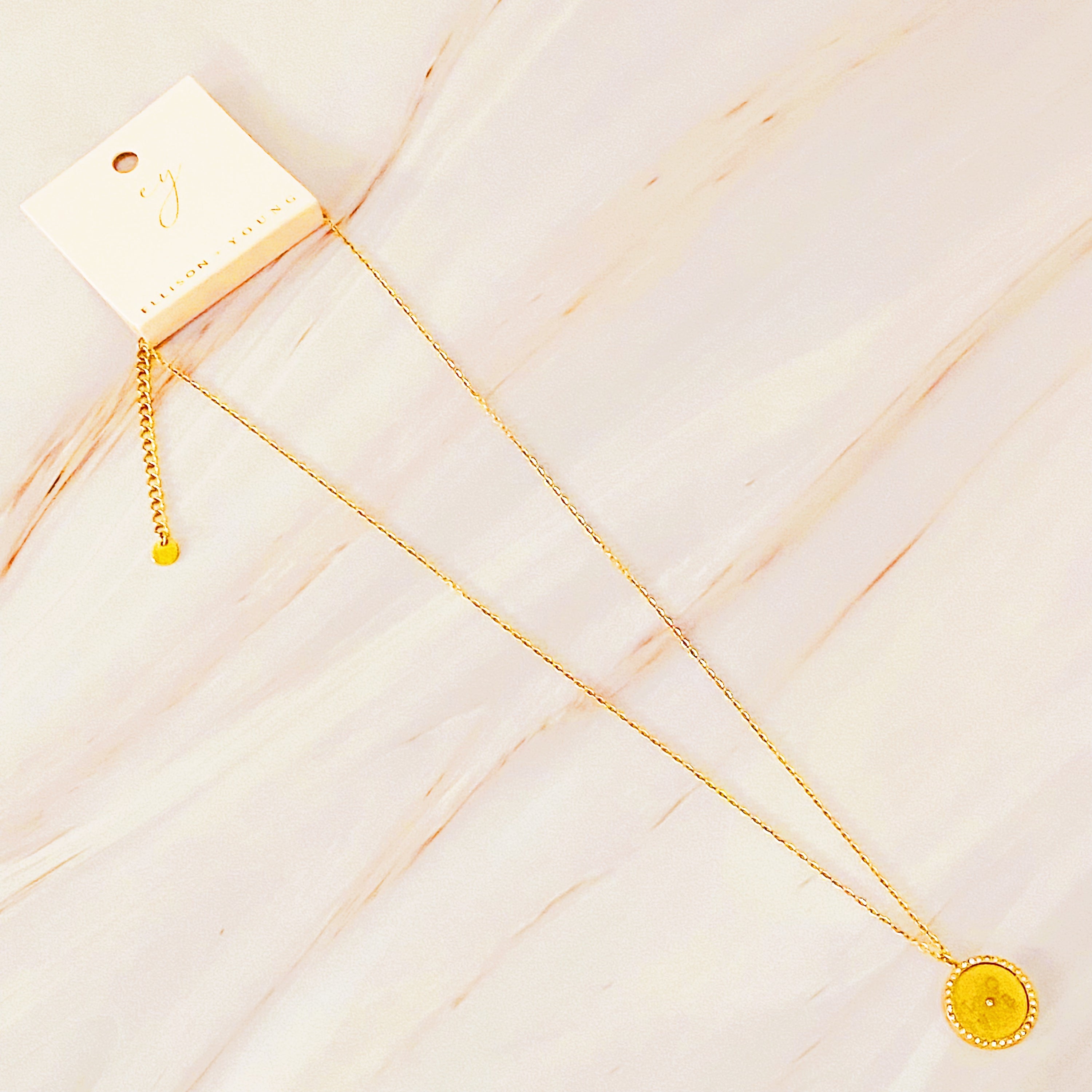 Loveholic Round Pendant Necklace featuring an engraved 'LOVE' design with sparkling cubic zirconia stones on an 18-inch gold plated chain.