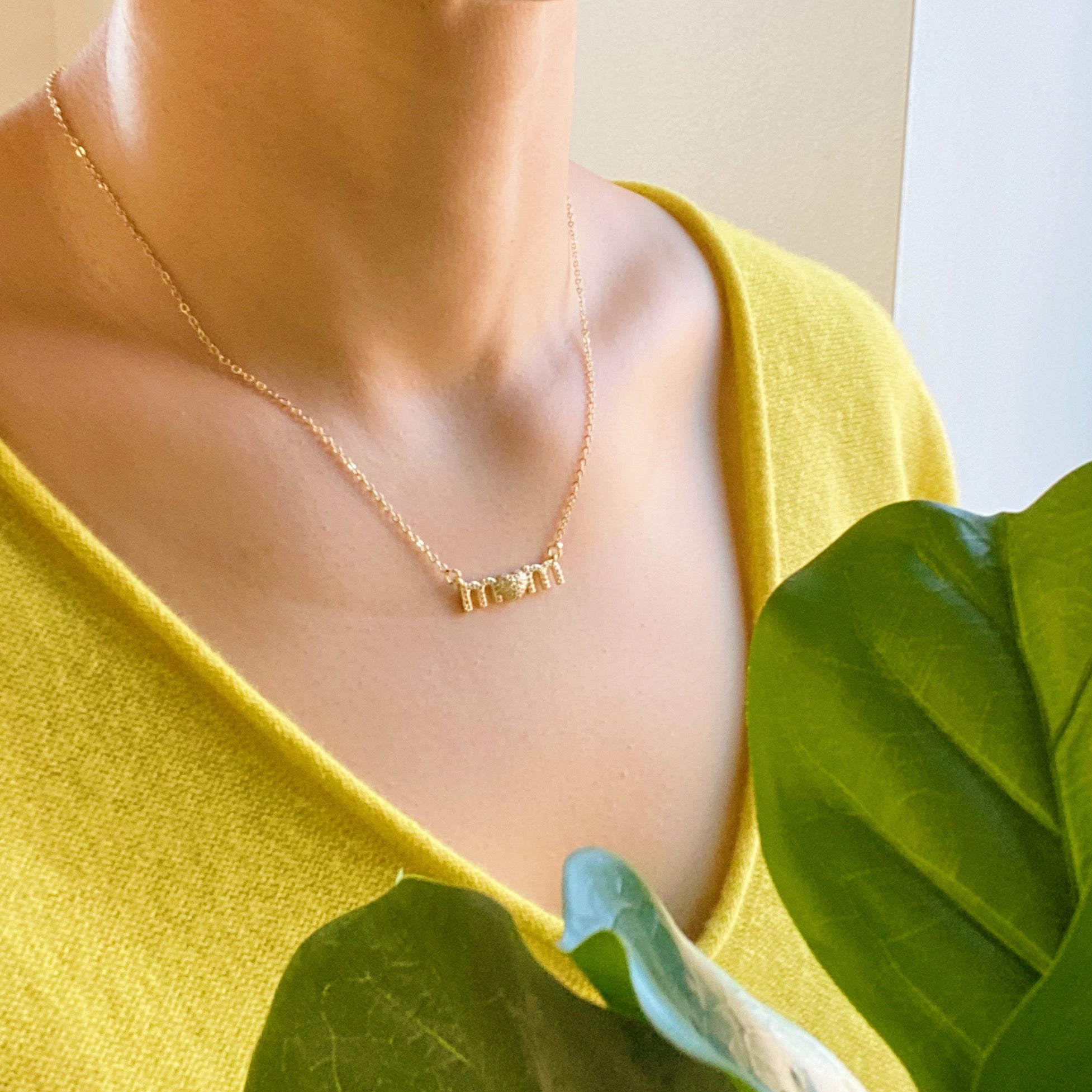 Lovely Mom Necklace featuring a heart-shaped pendant replacing the 'o' in 'mom', crafted from stainless steel and brass.