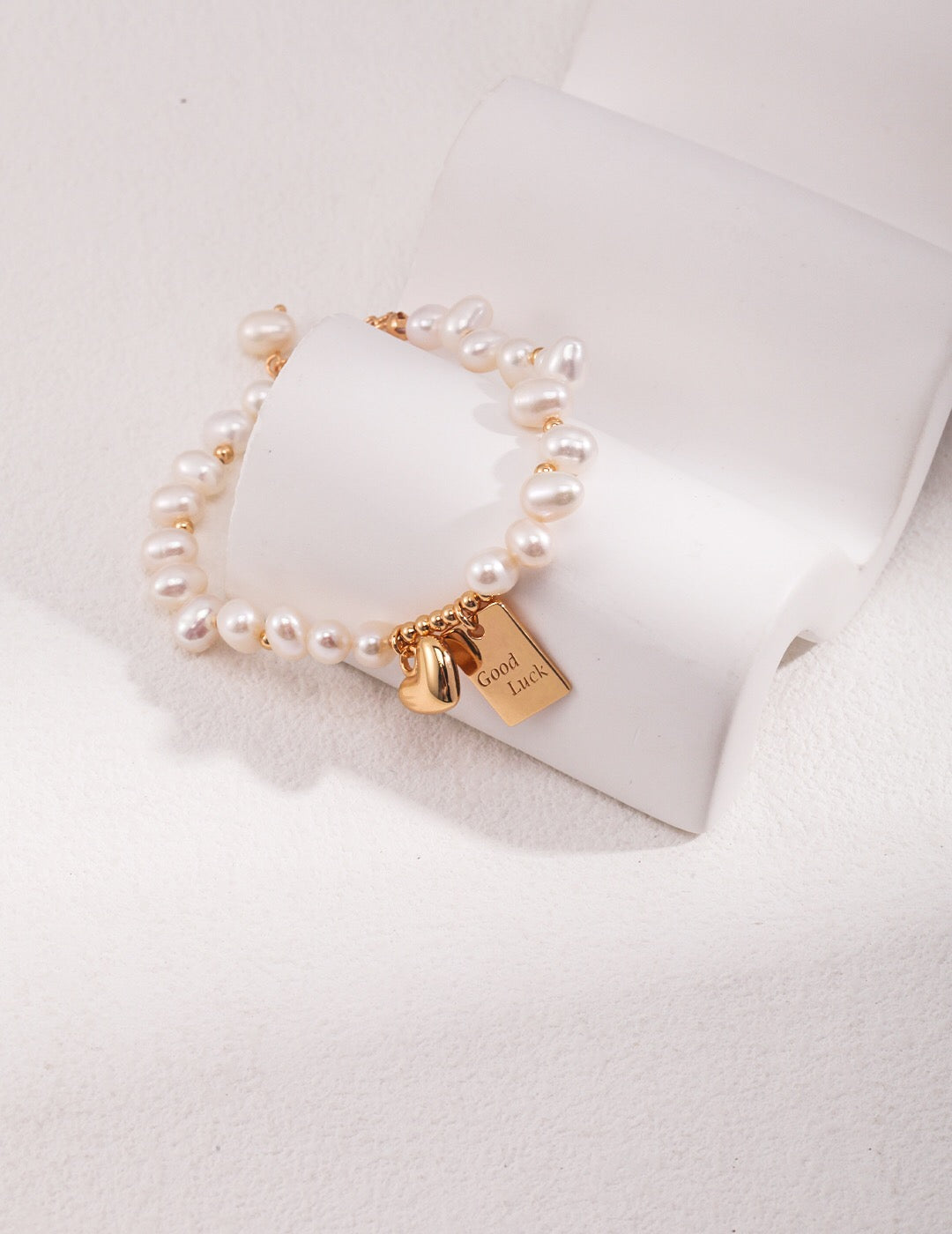 A beautiful Lucky Engraved Freshwater Pearls Bracelet featuring natural pearls, sterling silver, and gold vermeil, elegantly displayed on a soft surface.