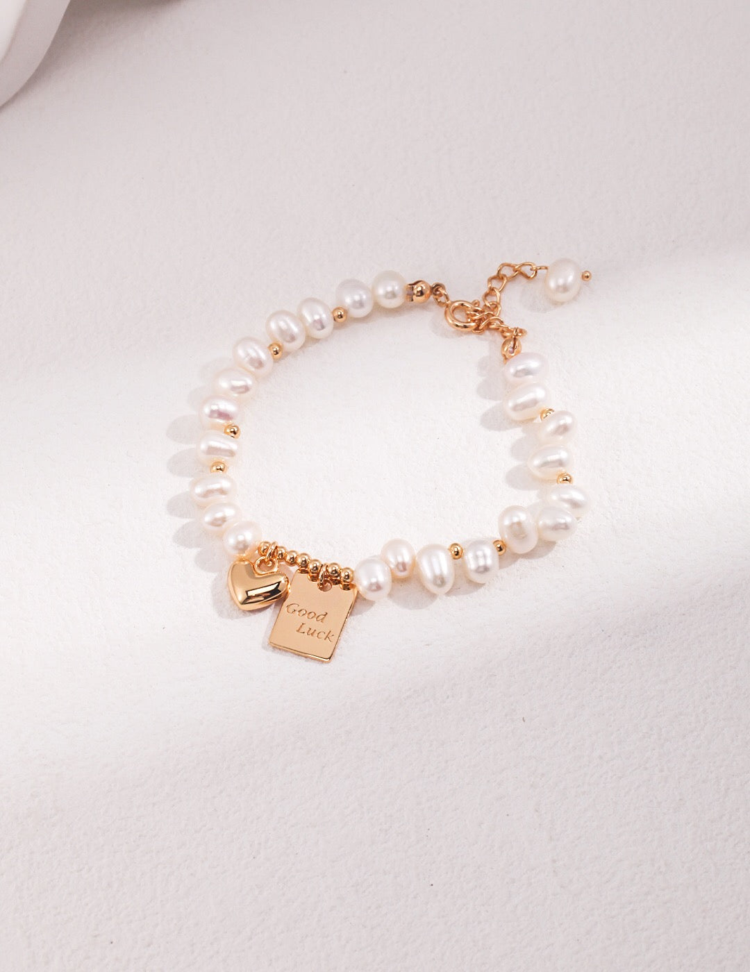 A beautiful Lucky Engraved Freshwater Pearls Bracelet featuring natural pearls, sterling silver, and gold vermeil, elegantly displayed on a soft surface.