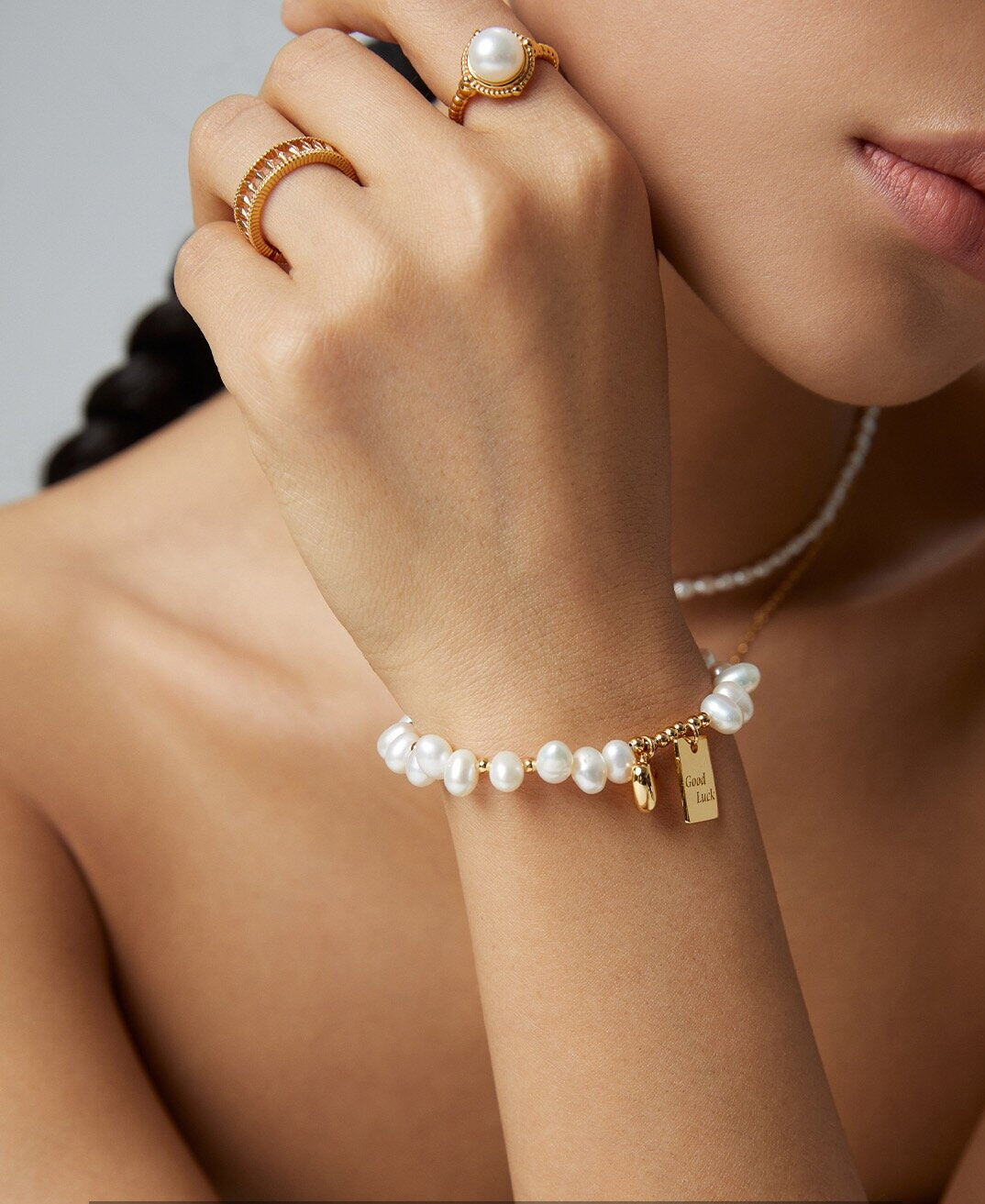 A beautiful Lucky Engraved Freshwater Pearls Bracelet featuring natural pearls, sterling silver, and gold vermeil, elegantly displayed on a soft surface.