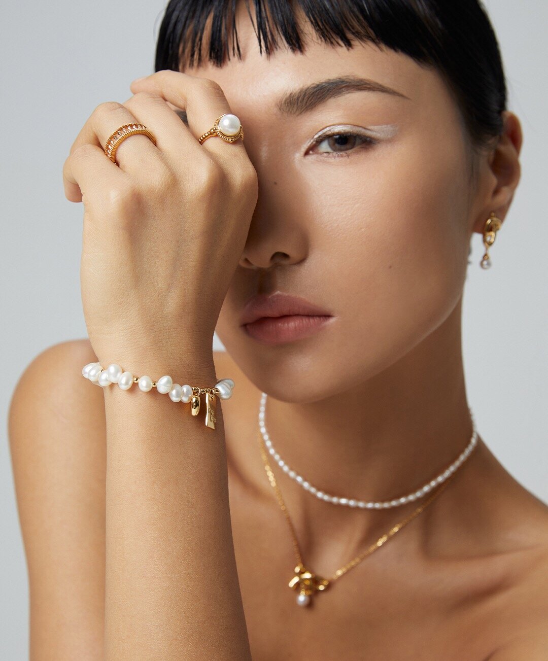 A beautiful Lucky Engraved Freshwater Pearls Bracelet featuring natural pearls, sterling silver, and gold vermeil, elegantly displayed on a soft surface.