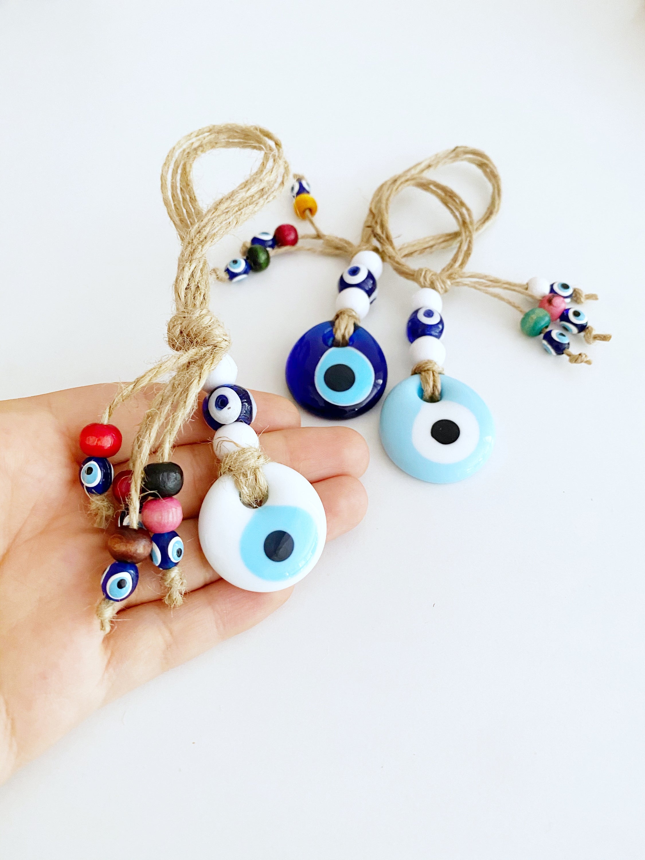 Handmade Lucky Evil Eye Bead charm for car rearview mirror, featuring a white evil eye bead and colorful glass beads.