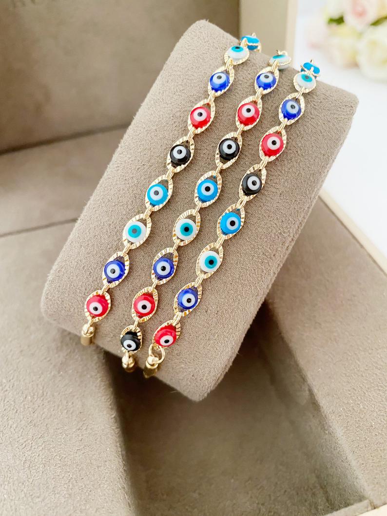 A multicolor adjustable Lucky Evil Eye Bracelet featuring tiny evil eye charms and gold accents, made from tarnish-resistant stainless steel.