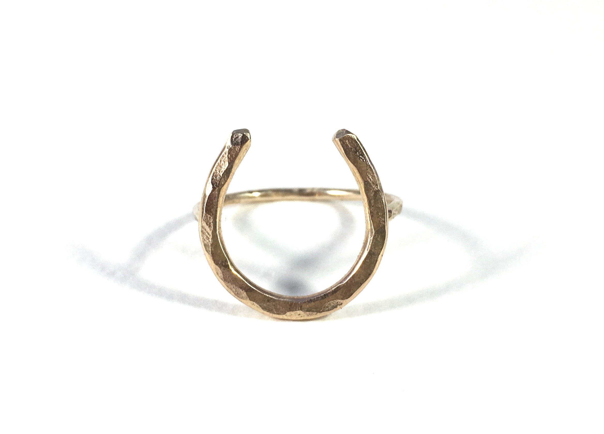 A large handmade lucky horseshoe ring crafted from recycled metal, showcasing its unique design and craftsmanship.