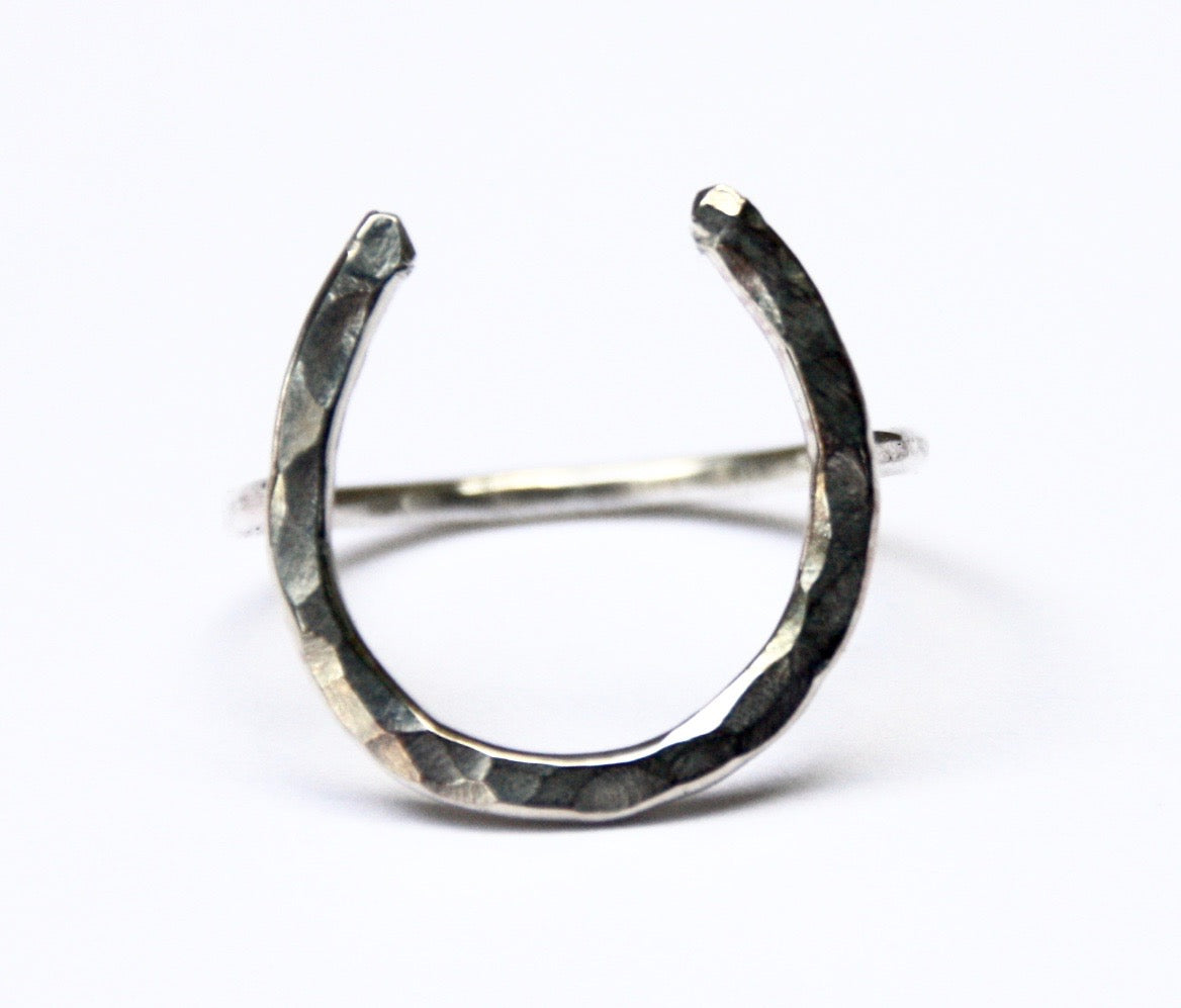 A large handmade lucky horseshoe ring crafted from recycled metal, showcasing its unique design and craftsmanship.