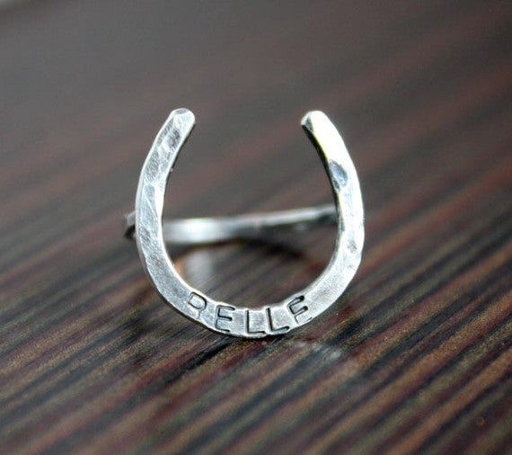 A large handmade lucky horseshoe ring crafted from recycled metal, showcasing its unique design and craftsmanship.