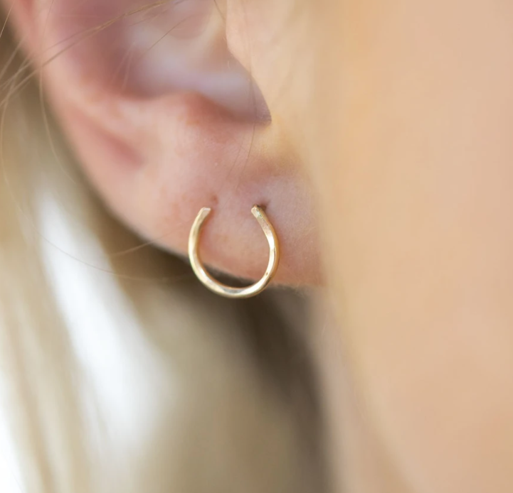 A pair of handmade Lucky Horseshoe Stud Earrings crafted from recycled metals, showcasing a classic western design.