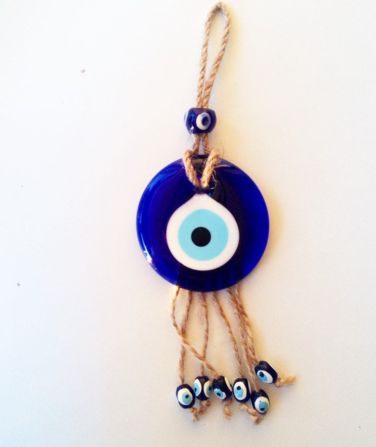 Handmade macrame wall hanging featuring a large blue evil eye and seven smaller evil eyes, symbolizing protection and positivity.