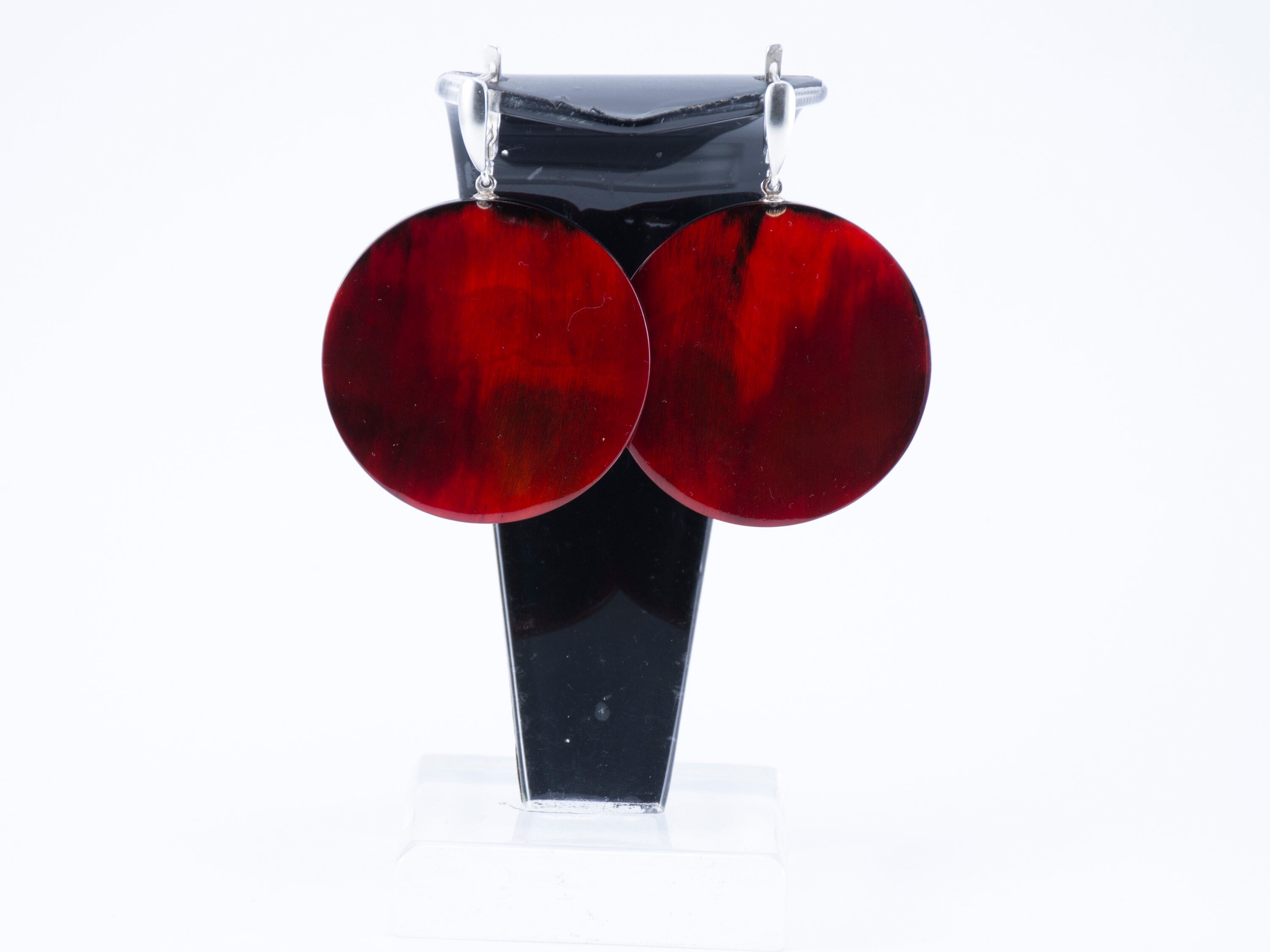 Elegant Magic Back Earrings made from buffalo horn, featuring a rich red color and silver locks, showcasing unique craftsmanship.