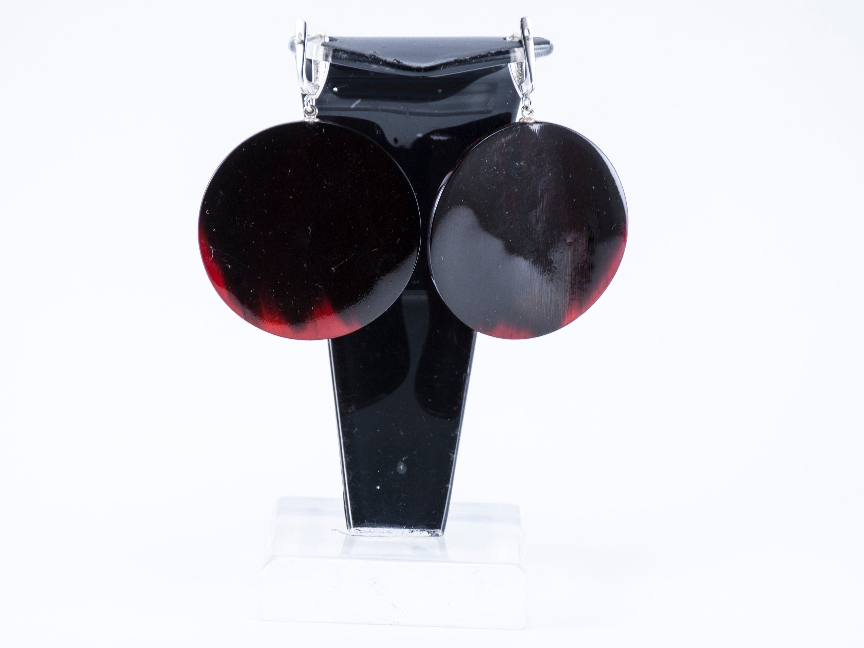 Elegant Magic Back Earrings made from buffalo horn, featuring a rich red color and silver locks, showcasing unique craftsmanship.