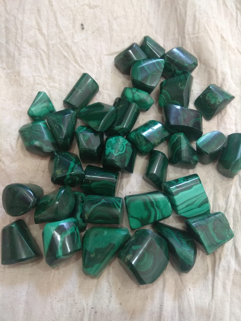 Natural green Malachite tumble stones, polished and smooth, showcasing unique patterns and colors.