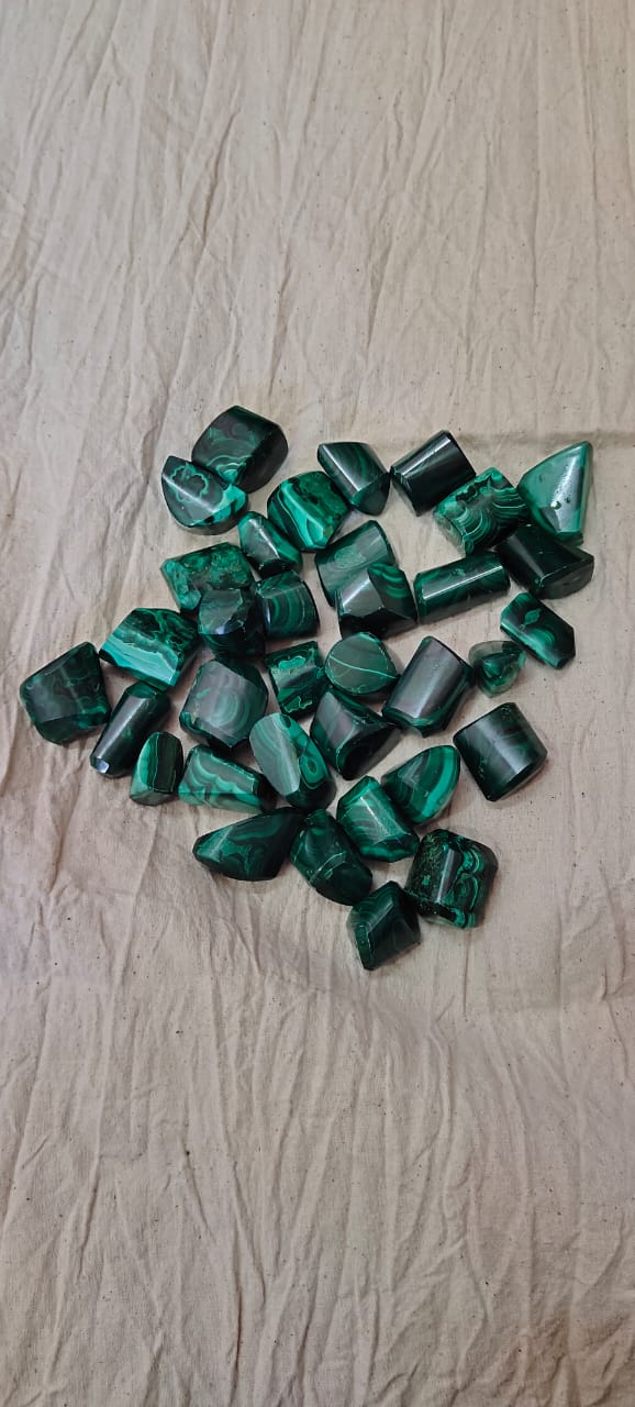 Natural green Malachite tumble stones, polished and smooth, showcasing unique patterns and colors.