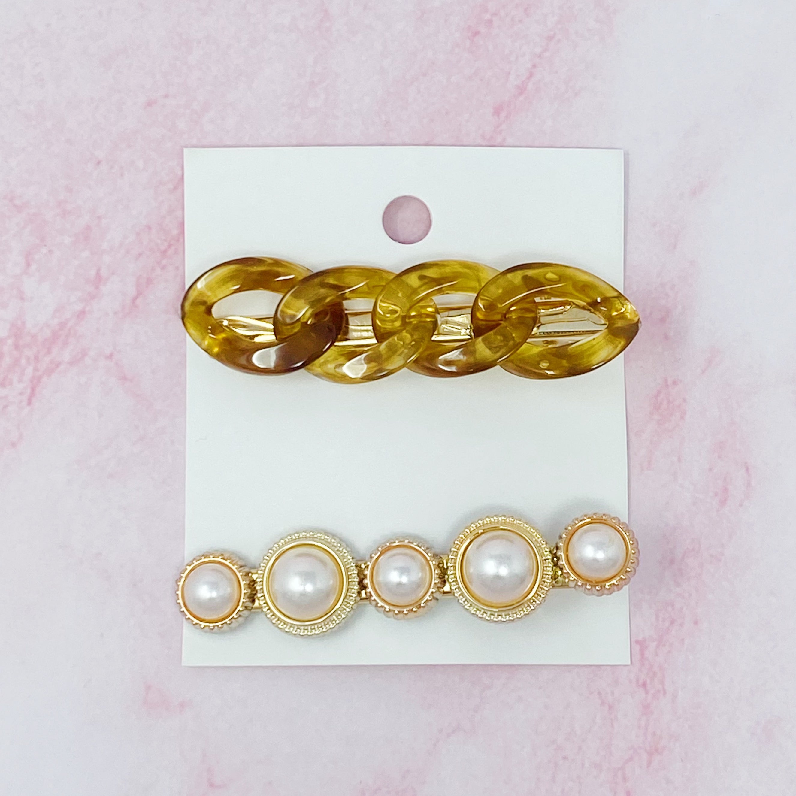 A stylish Marble Chain and Pearl Hair Clip Set featuring two elegant clips with neutral marble chains and pearl accents.