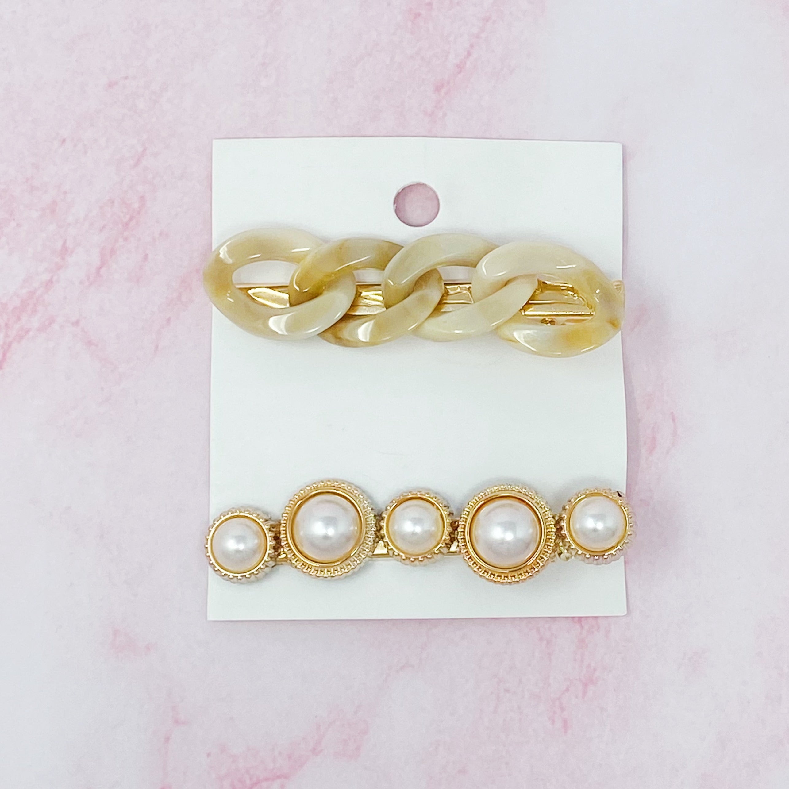 A stylish Marble Chain and Pearl Hair Clip Set featuring two elegant clips with neutral marble chains and pearl accents.