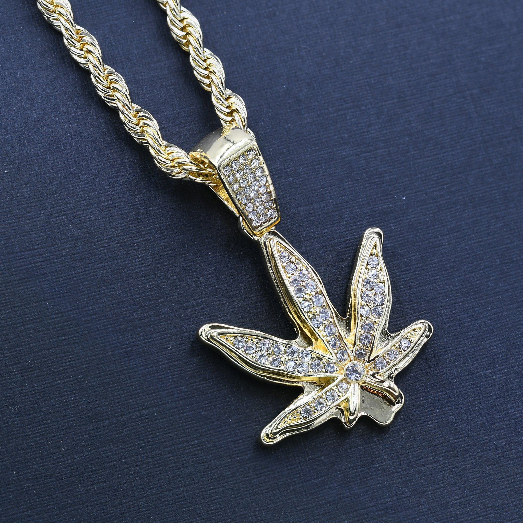 Intricate marijuana leaf chain and charm with crystal stones on a 24'' rope chain, showcasing hip-hop style.