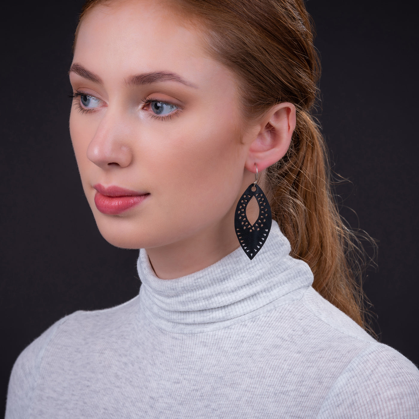 A pair of Marquise Intricate Recycled Rubber Earrings, showcasing unique designs crafted from reclaimed inner tubes with sterling silver hooks.