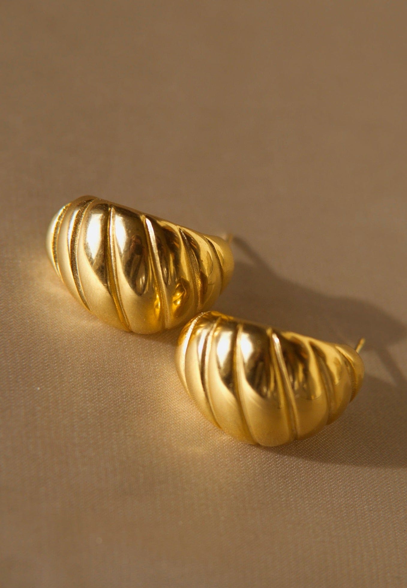 Mathilde Croissant Hoop earrings in 18Kt yellow gold plated stainless steel, showcasing a unique twisted design.