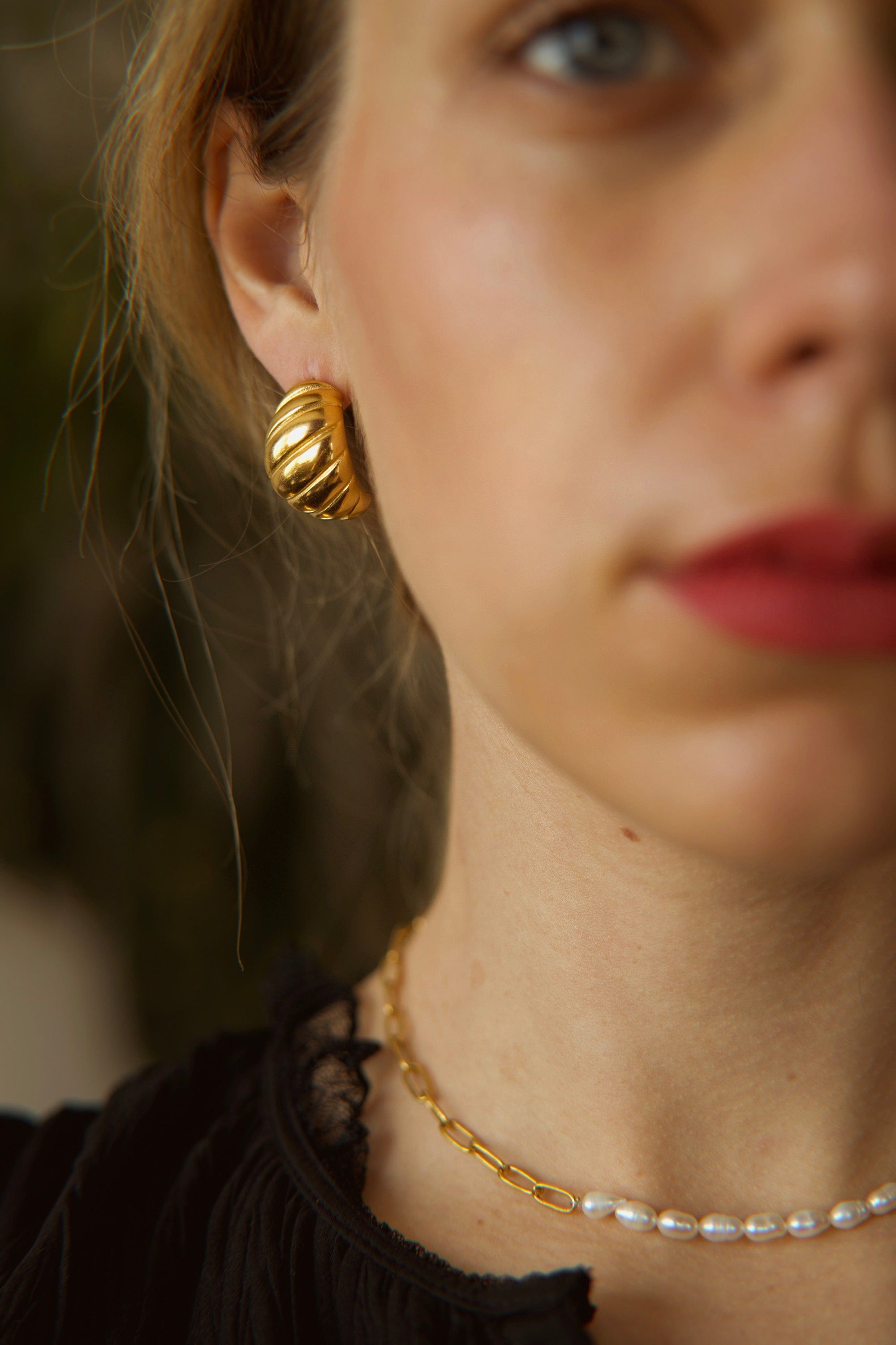 Mathilde Croissant Hoop earrings in 18Kt yellow gold plated stainless steel, showcasing a unique twisted design.