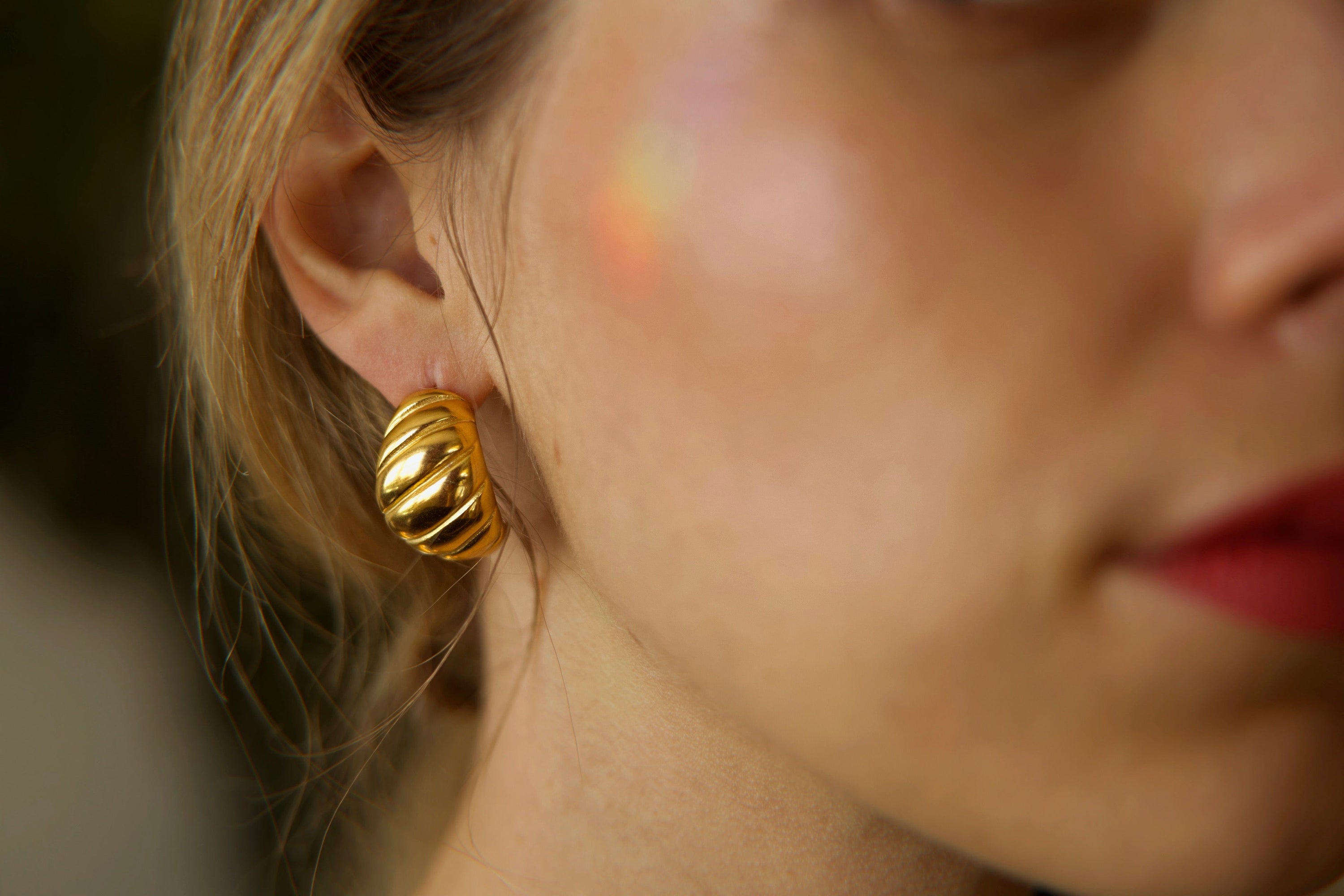 Mathilde Croissant Hoop earrings in 18Kt yellow gold plated stainless steel, showcasing a unique twisted design.