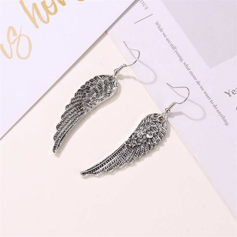 A pair of stylish metallic angel's wings earrings made from alloy, showcasing intricate detailing and a polished finish.