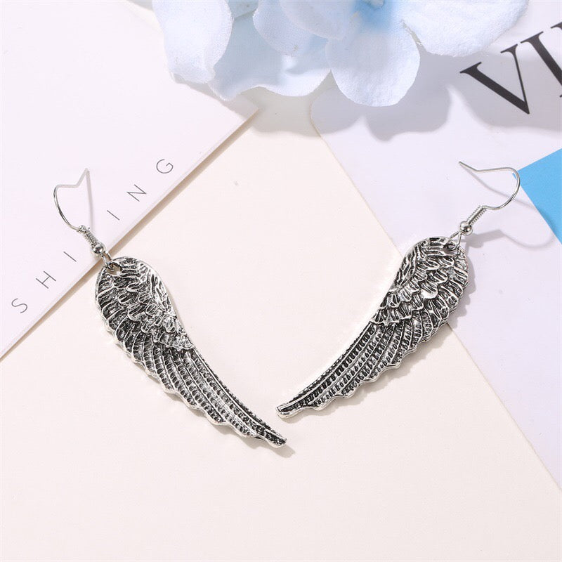 A pair of stylish metallic angel's wings earrings made from alloy, showcasing intricate detailing and a polished finish.