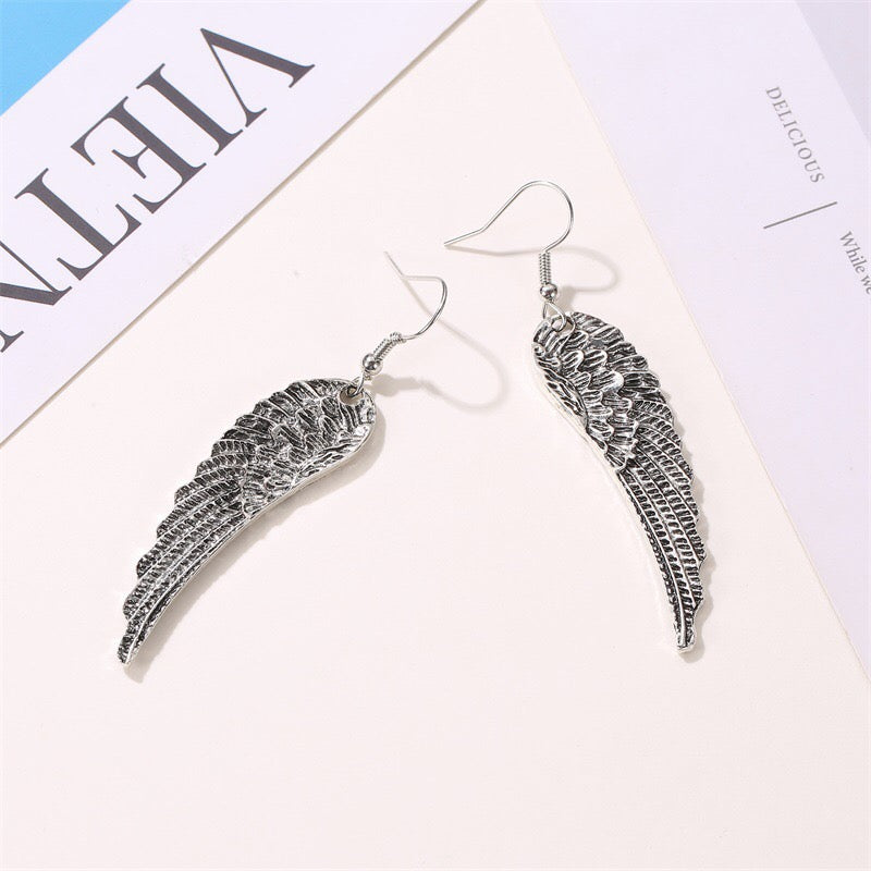 A pair of stylish metallic angel's wings earrings made from alloy, showcasing intricate detailing and a polished finish.