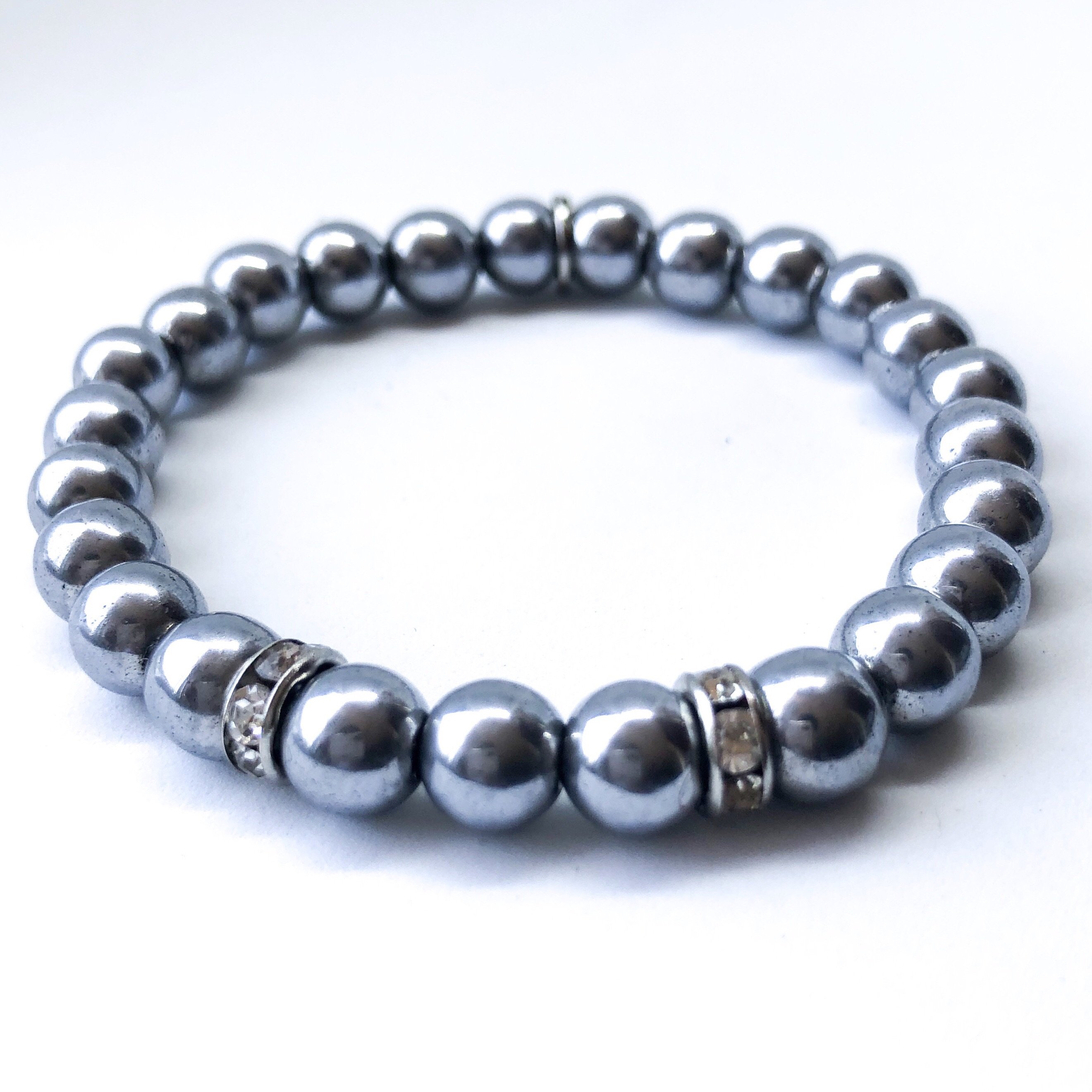 A stylish Metallic Lustre Bracelet made of hematite, showcasing its lustrous finish and adjustable design, perfect for layering.