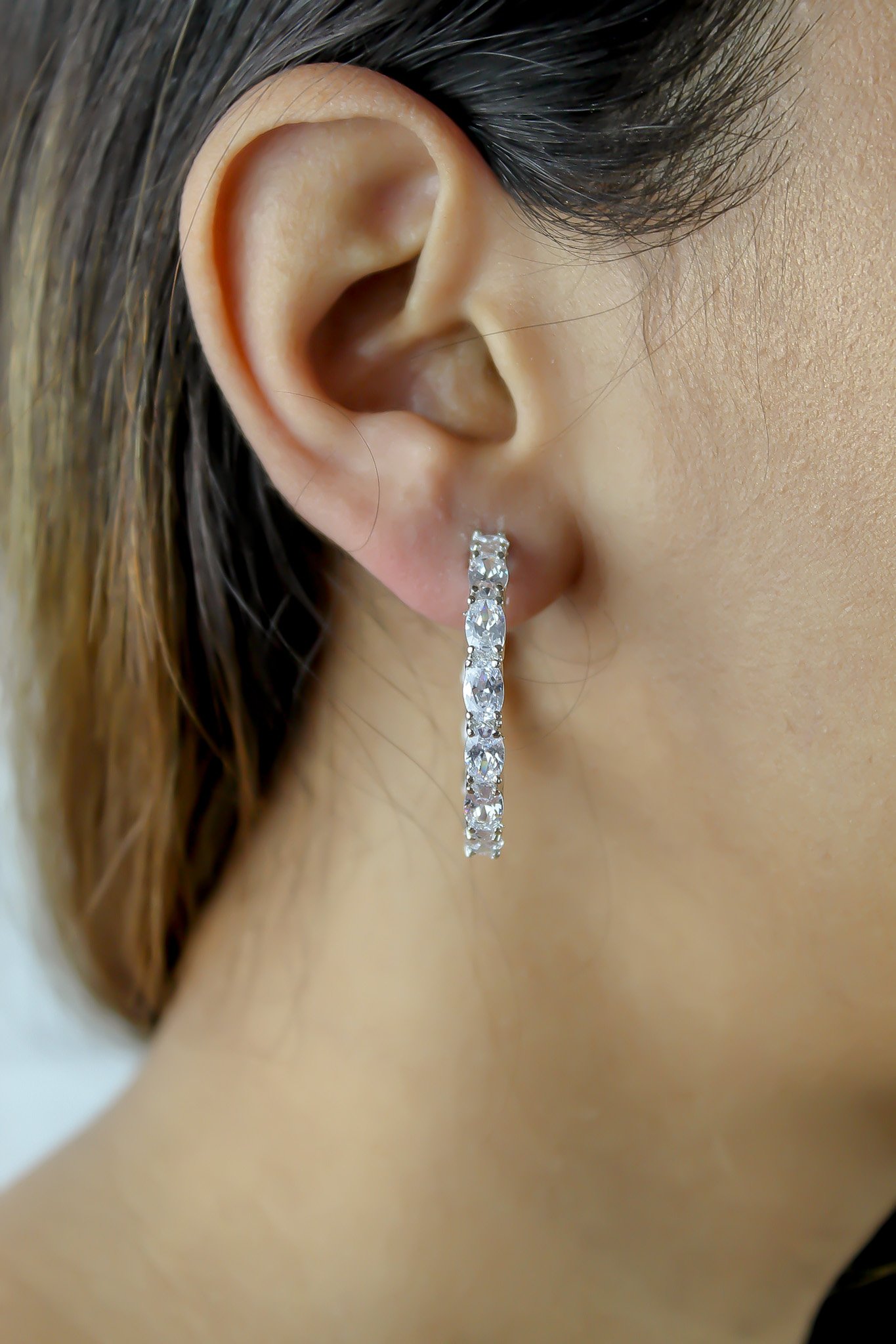 A pair of Milano Hoops earrings, silver-plated with sparkling zircons, showcasing their elegant design and lightweight structure.