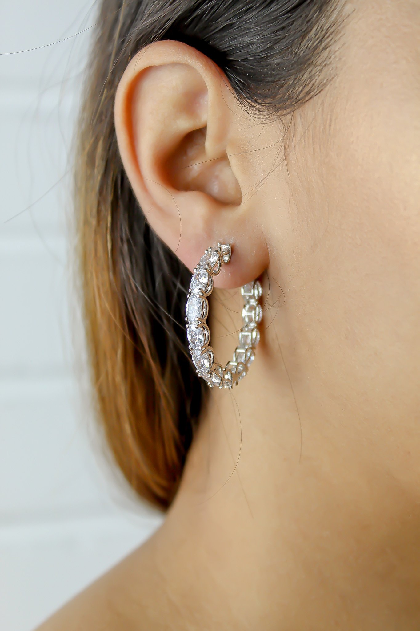 A pair of Milano Hoops earrings, silver-plated with sparkling zircons, showcasing their elegant design and lightweight structure.