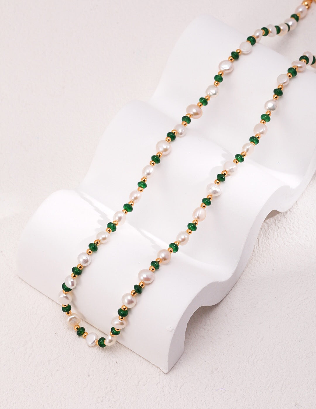 A delicate Mini Emerald Freshwater Pearl Necklace featuring sterling silver and gold vermeil, adorned with emerald stones and irregular freshwater pearls.