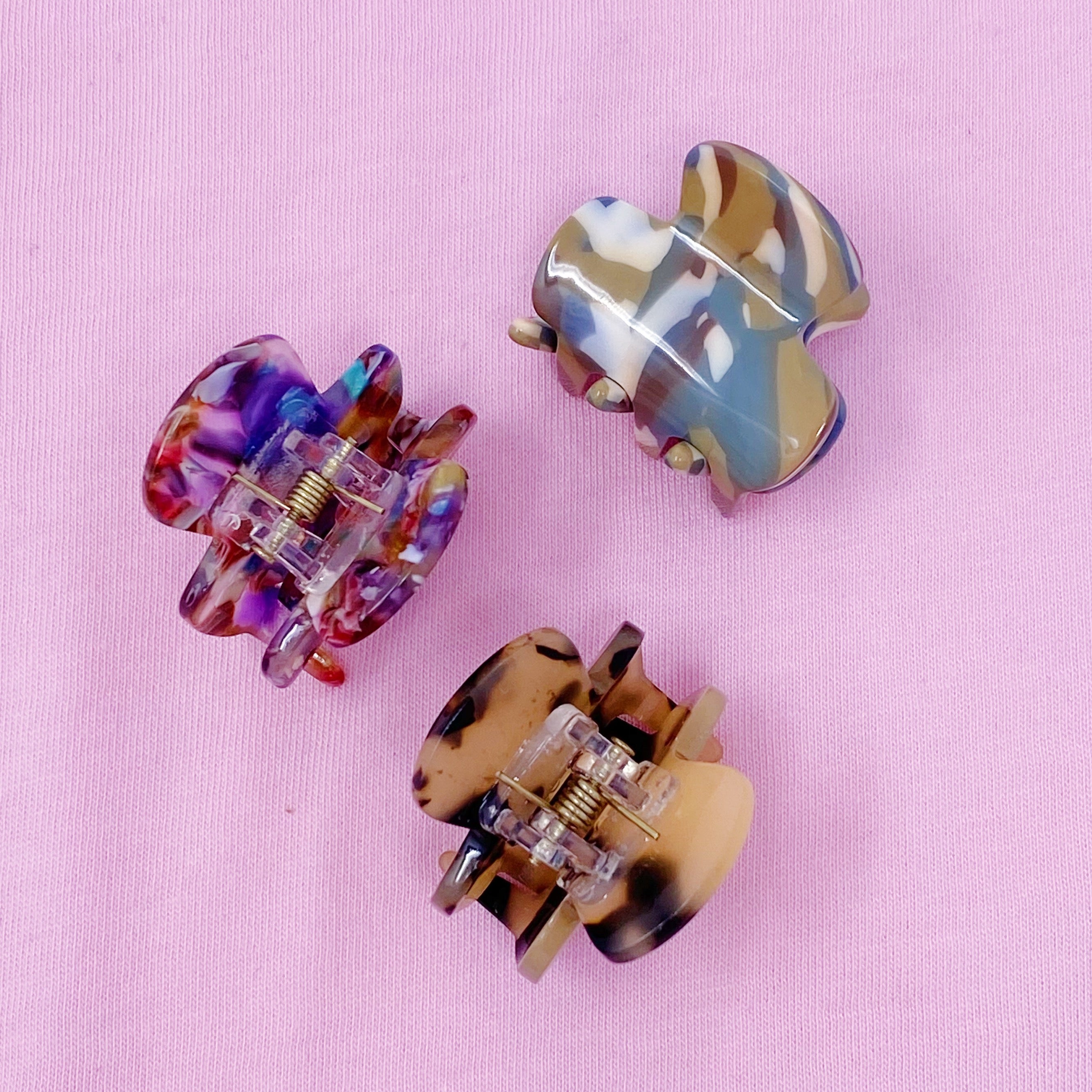 Mini acrylic hair claw clip in various tortoise designs, perfect for securing half-up hairstyles.