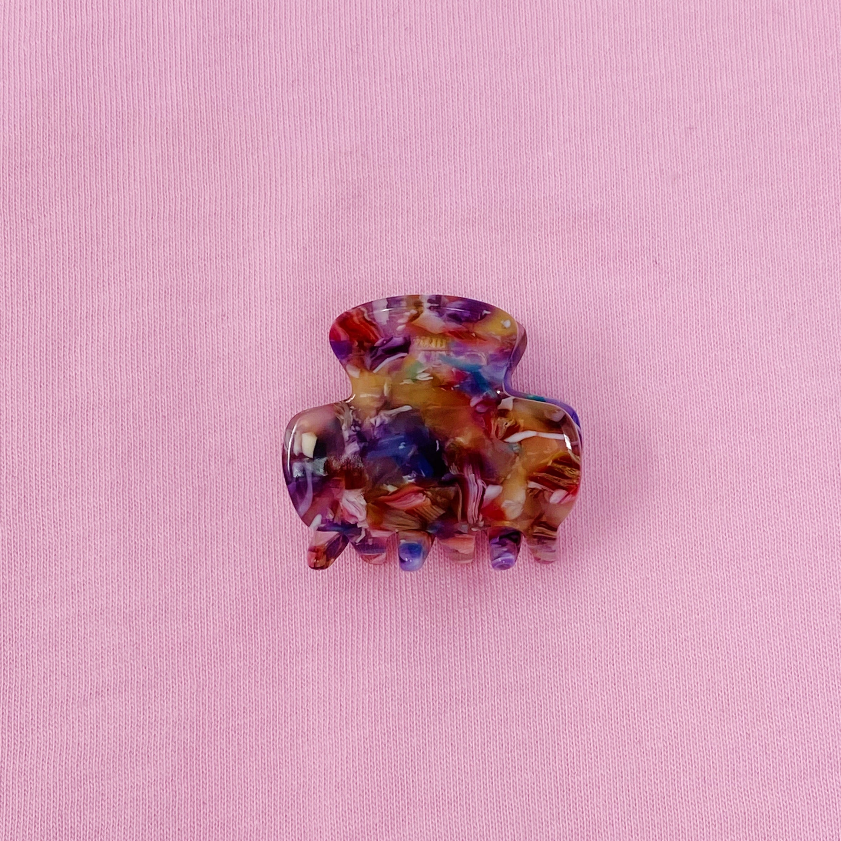 Mini acrylic hair claw clip in various tortoise designs, perfect for securing half-up hairstyles.