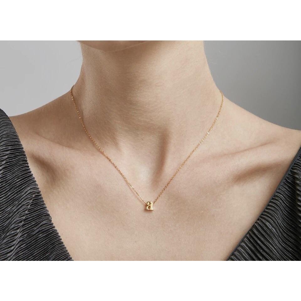 A delicate Mini Initial Necklace featuring an 18k gold plated lowercase initial, perfect for layering and gifting.