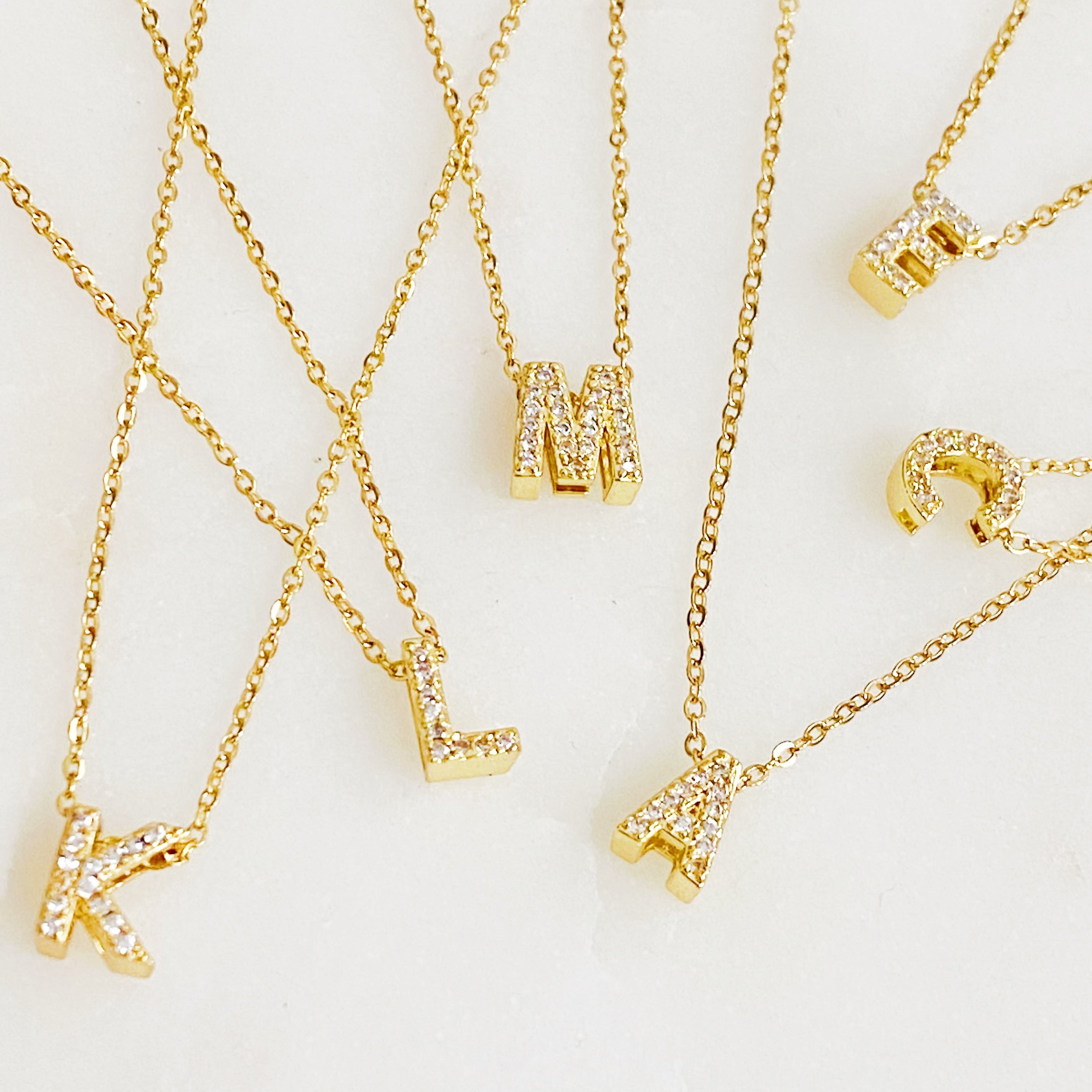 Mini Keepsake Initial Necklace featuring a small initial pendant on a dainty gold plated chain with cubic zirconia accents.