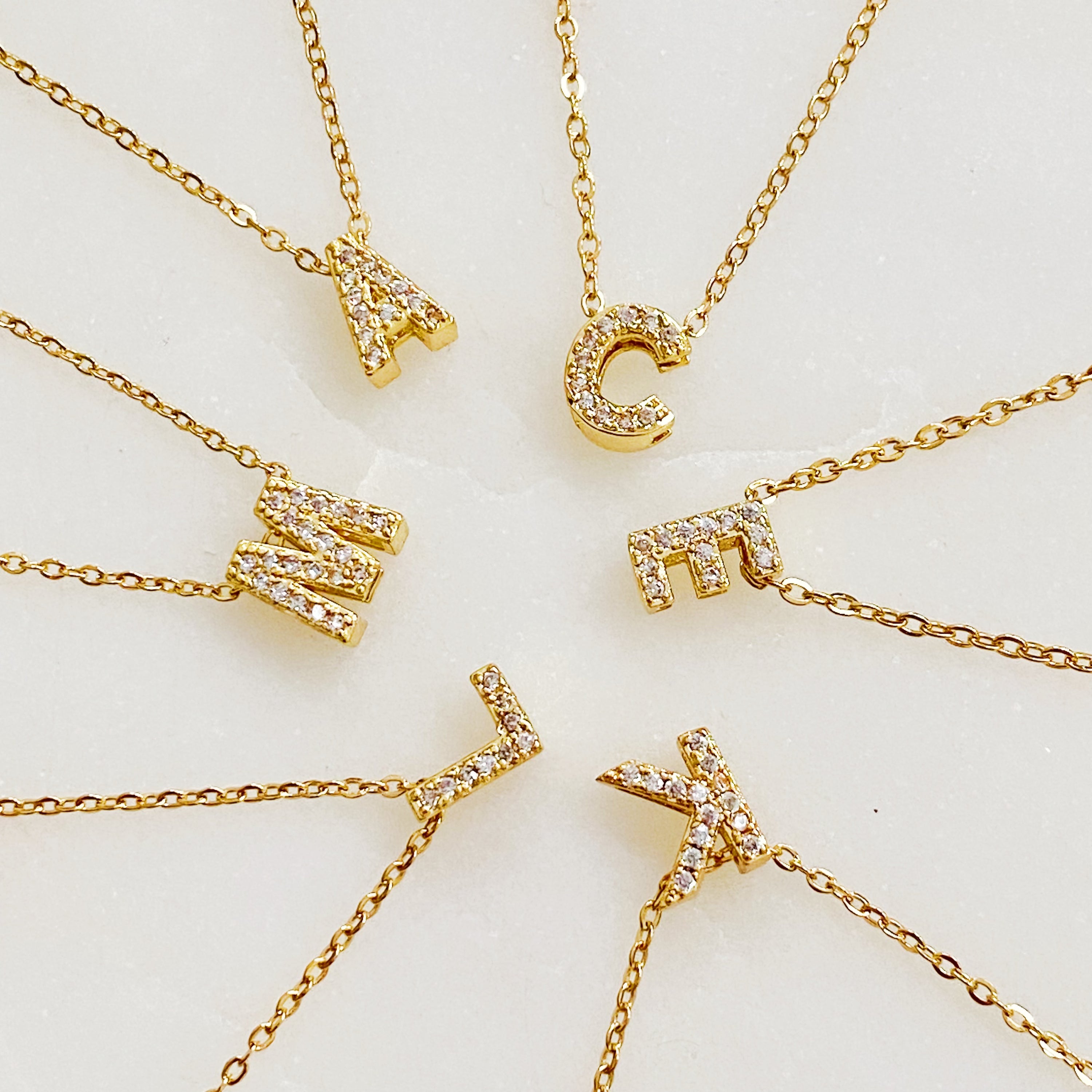 Mini Keepsake Initial Necklace featuring a small initial pendant on a dainty gold plated chain with cubic zirconia accents.