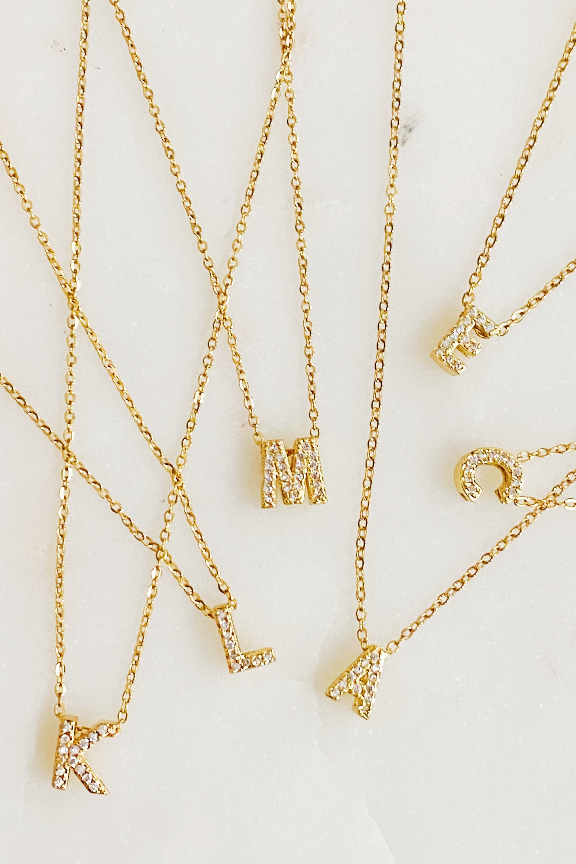 Mini Keepsake Initial Necklace featuring a small initial pendant on a dainty gold plated chain with cubic zirconia accents.