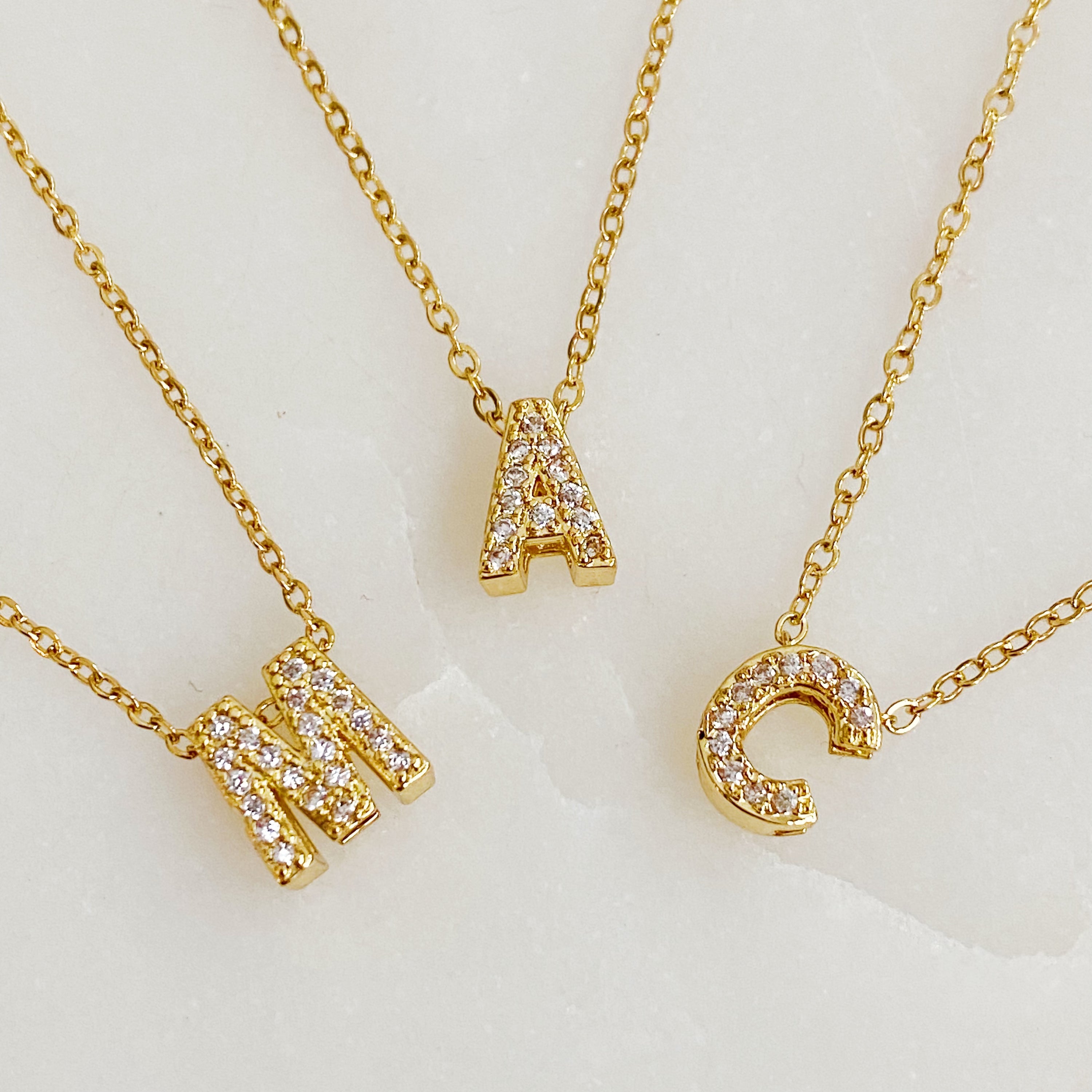 Mini Keepsake Initial Necklace featuring a small initial pendant on a dainty gold plated chain with cubic zirconia accents.