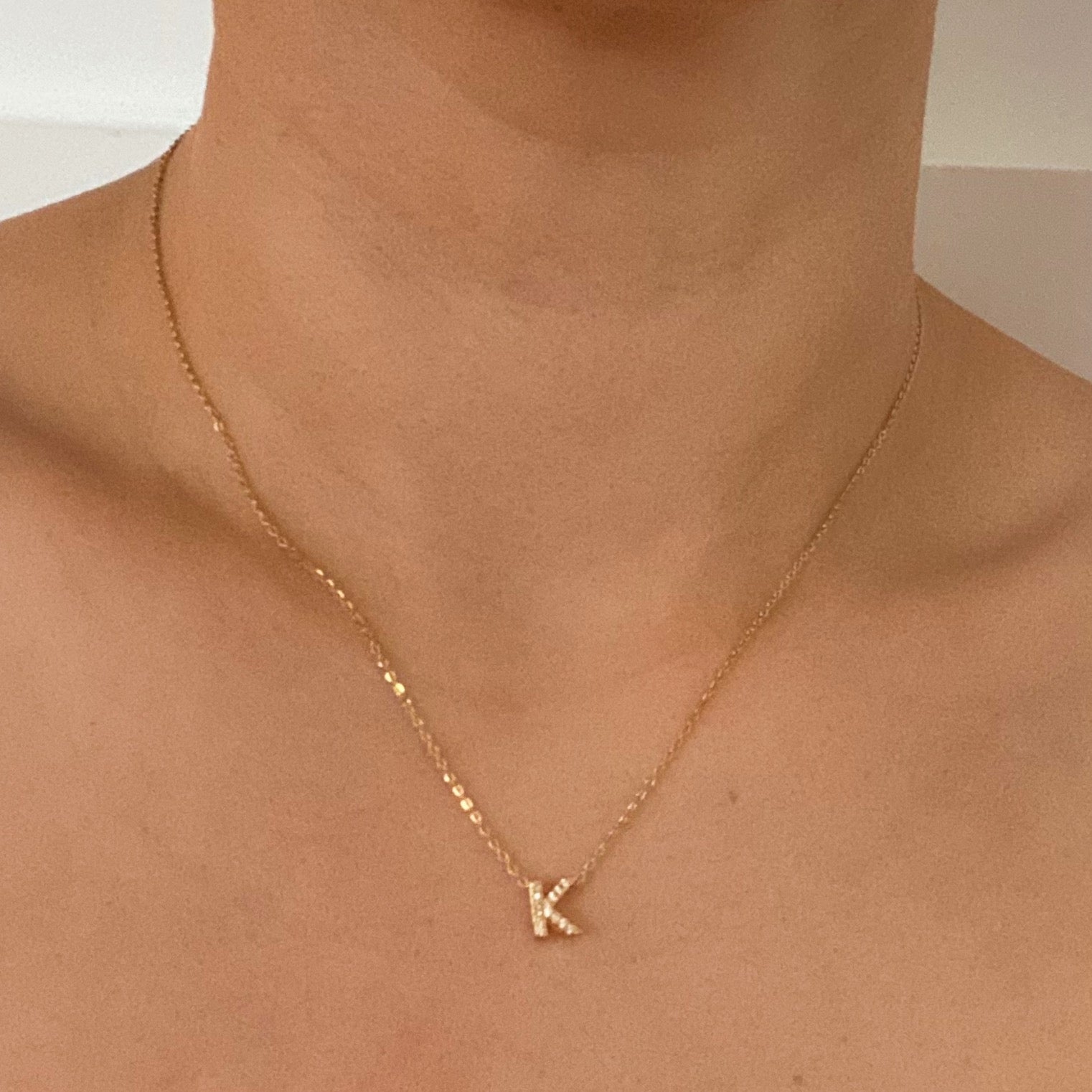 Mini Keepsake Initial Necklace featuring a small initial pendant on a dainty gold plated chain with cubic zirconia accents.