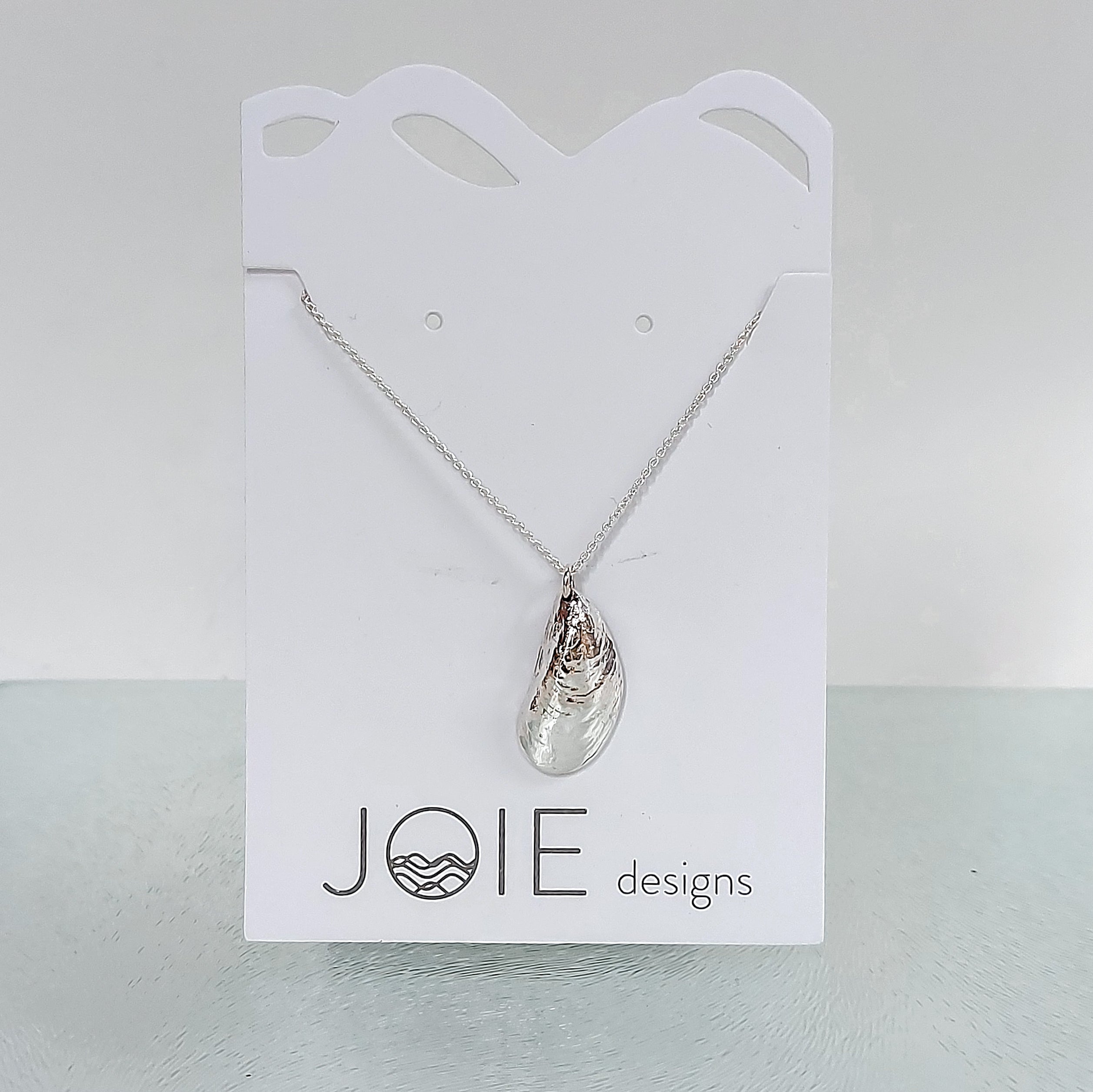 A delicate Mini Moanna Mussel Shell Necklace made of sterling silver, showcasing intricate details and a petite design.