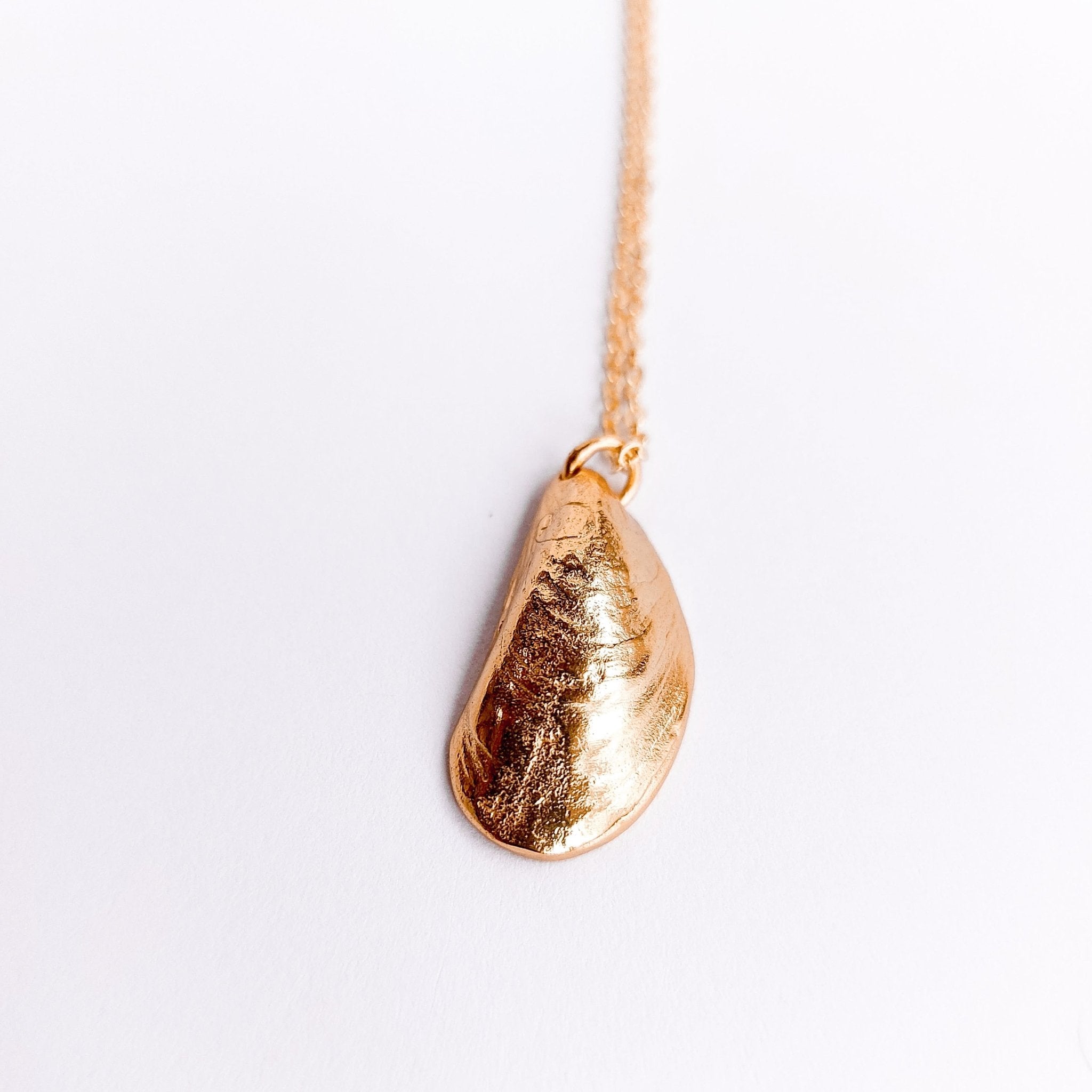 A delicate Mini Moanna Mussel Shell Necklace made of sterling silver, showcasing intricate details and a petite design.