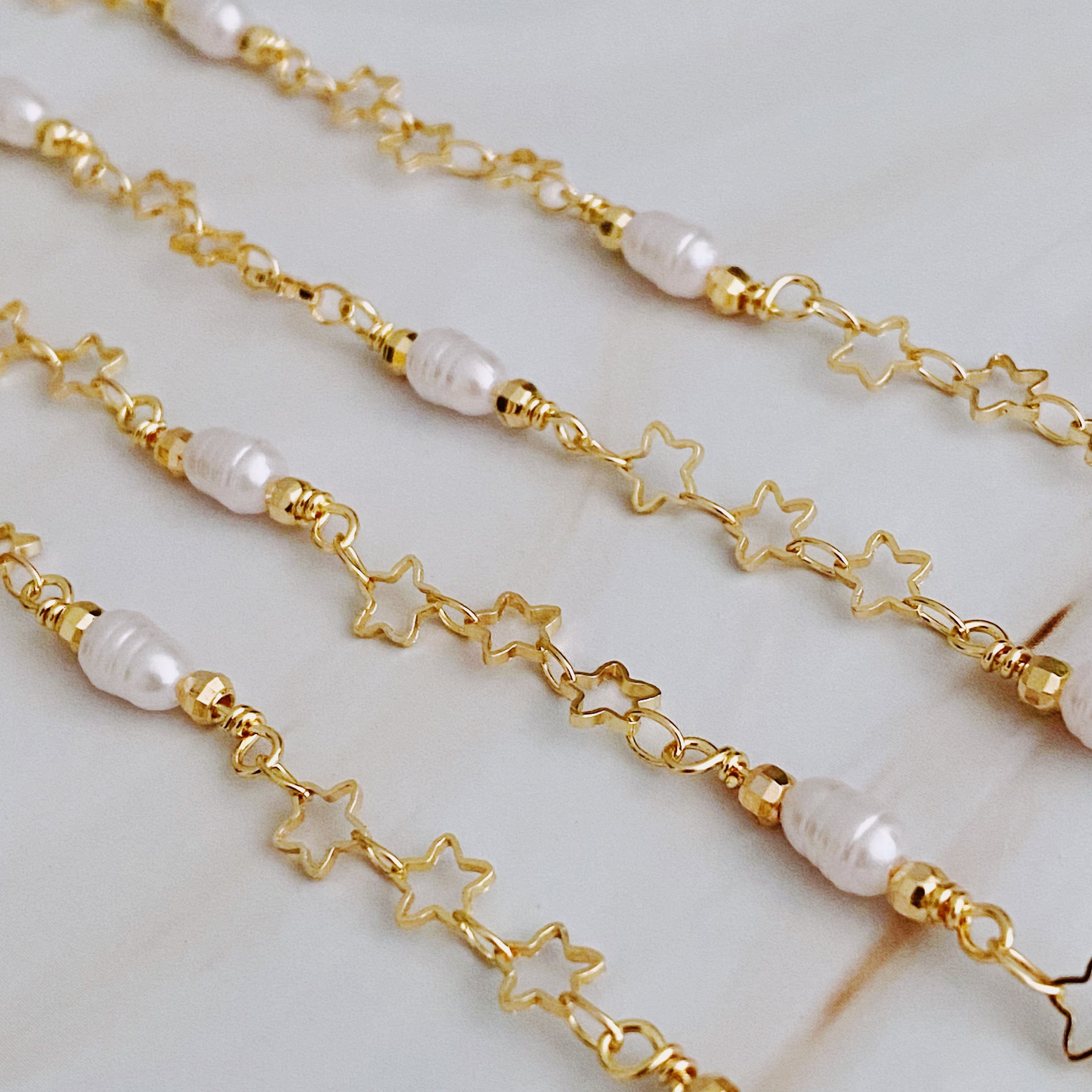 Mini Pearl Mini Star Long Chain Necklace featuring delicate stars and pearl beads, elegantly designed for versatile styling.