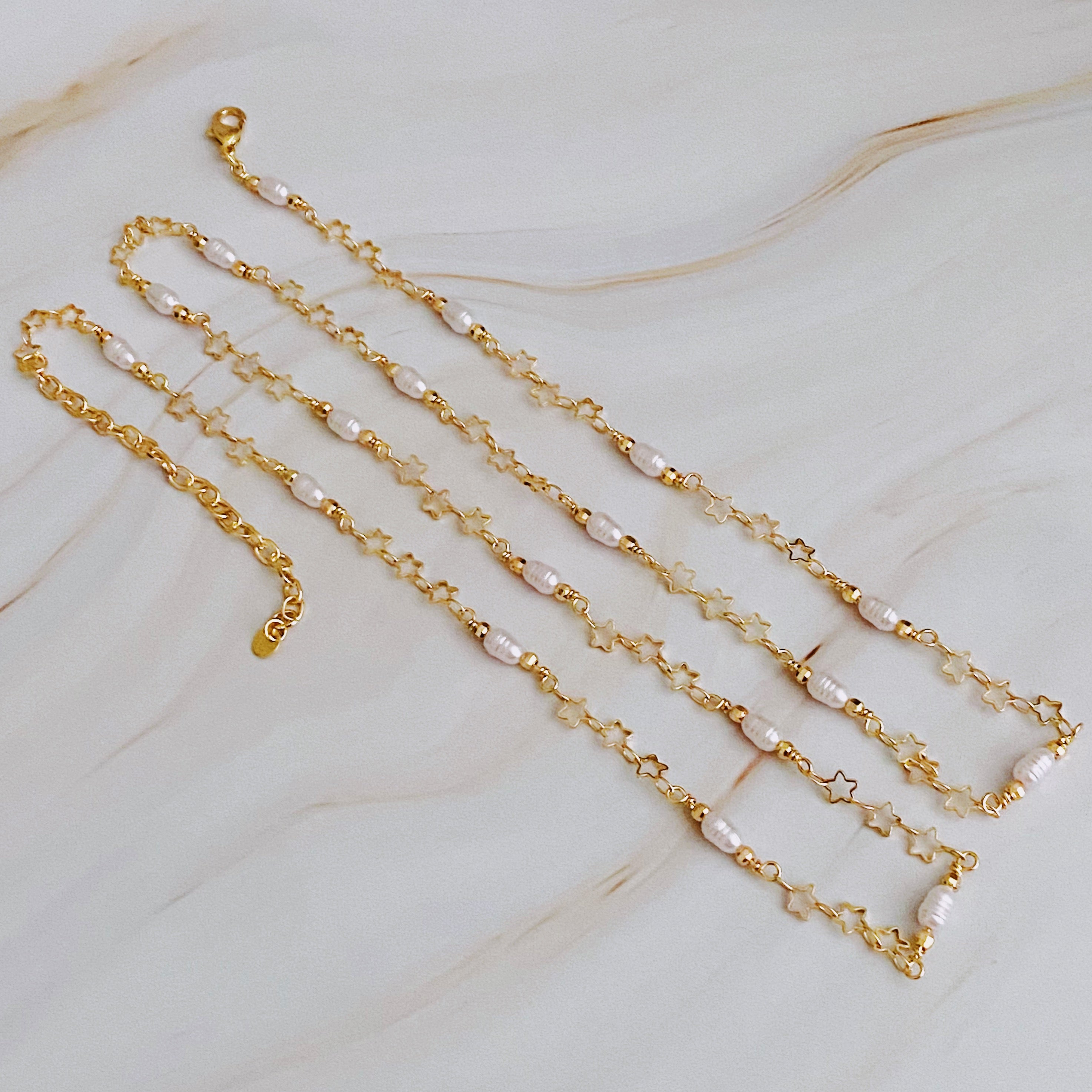 Mini Pearl Mini Star Long Chain Necklace featuring delicate stars and pearl beads, elegantly designed for versatile styling.