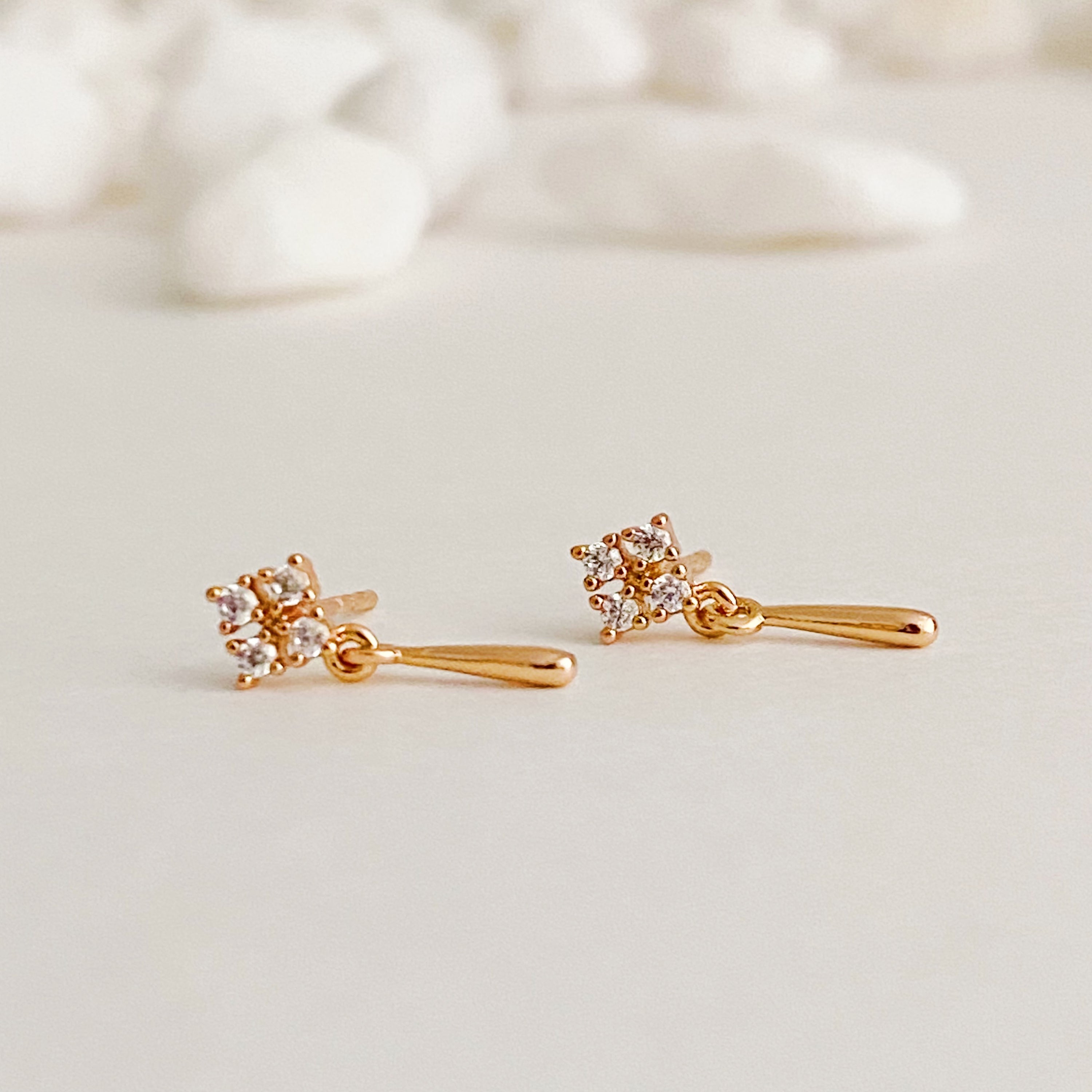 Mini Twinkle Dangle Earrings featuring delicate teardrop design with cubic zirconia sparkles, elegantly crafted in gold plated brass.