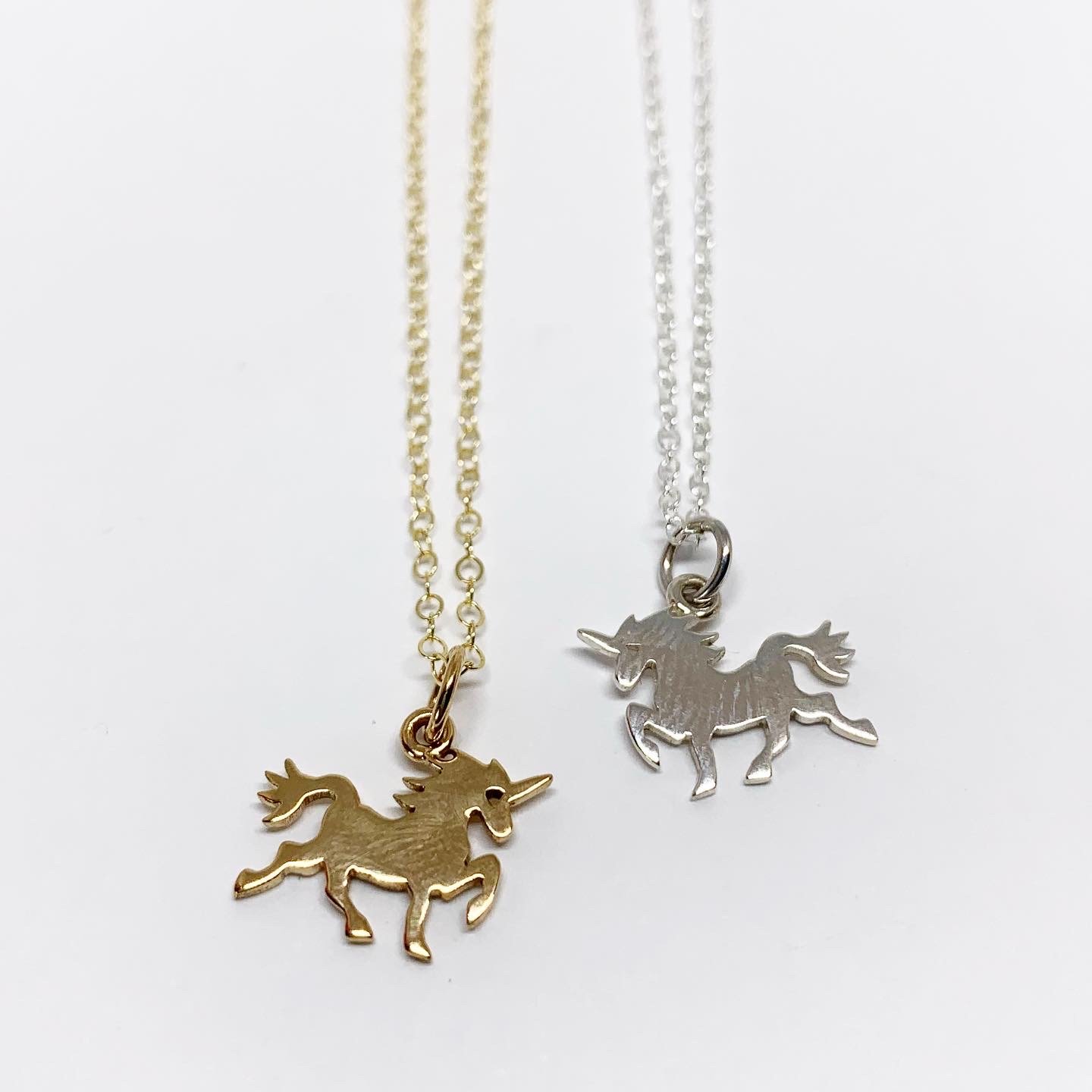 A delicate mini unicorn charm necklace featuring a sterling silver or brass pendant on a yellow gold fill chain, perfect for horse lovers.