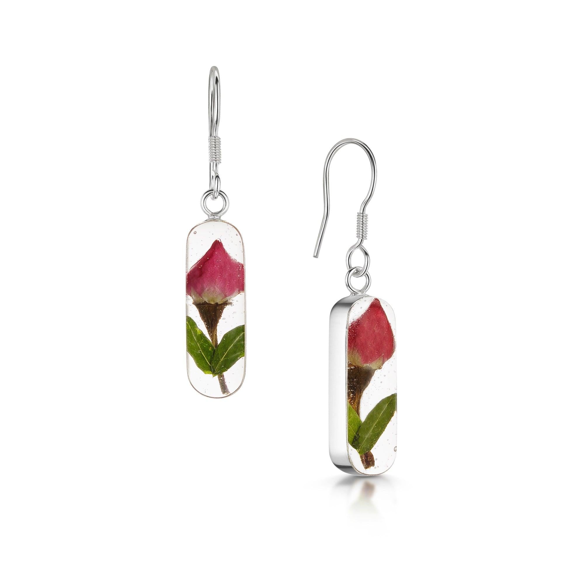 Elegant sterling silver drop earrings featuring real miniature rose buds encased in resin, part of the Leela collection.